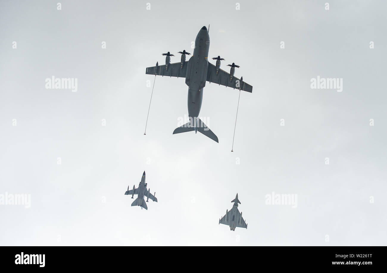 Wunstorf/Steinhude, Niedersachsen, Deutschland. 5. Juli 2019. Ein Airbus A400M-Transportflugzeuge (o) vor einem Panavia 200 (PA-200) Tornado Kampfjet (l) und Eurofighter Typhoon Mehrzweck- Kampfflugzeuge (r) über Wunstorf Air Base fliegt. Die Transportflugzeuge in Wunstorf Air Base stationiert sind aus Jordanien verwendet werden Kampfflugzeuge im Kampf gegen die islamischen Staat zu tanken (IST). Foto: Christophe Kirschtorte/dpa Quelle: dpa Picture alliance/Alamy leben Nachrichten Stockfoto