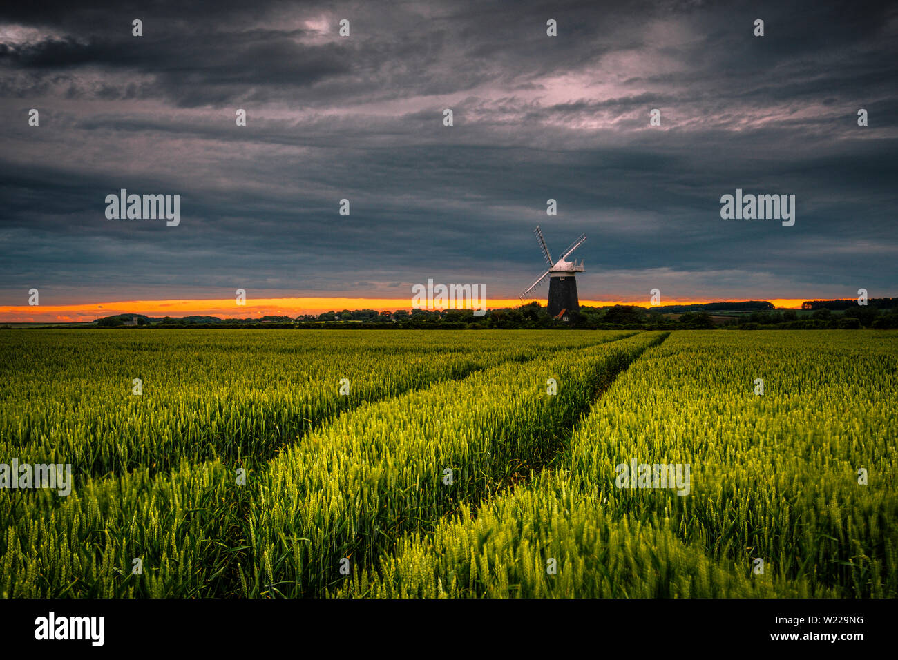 Die Sonne geht hinter Burnham Overy Windmühle in Norfolk. Stockfoto