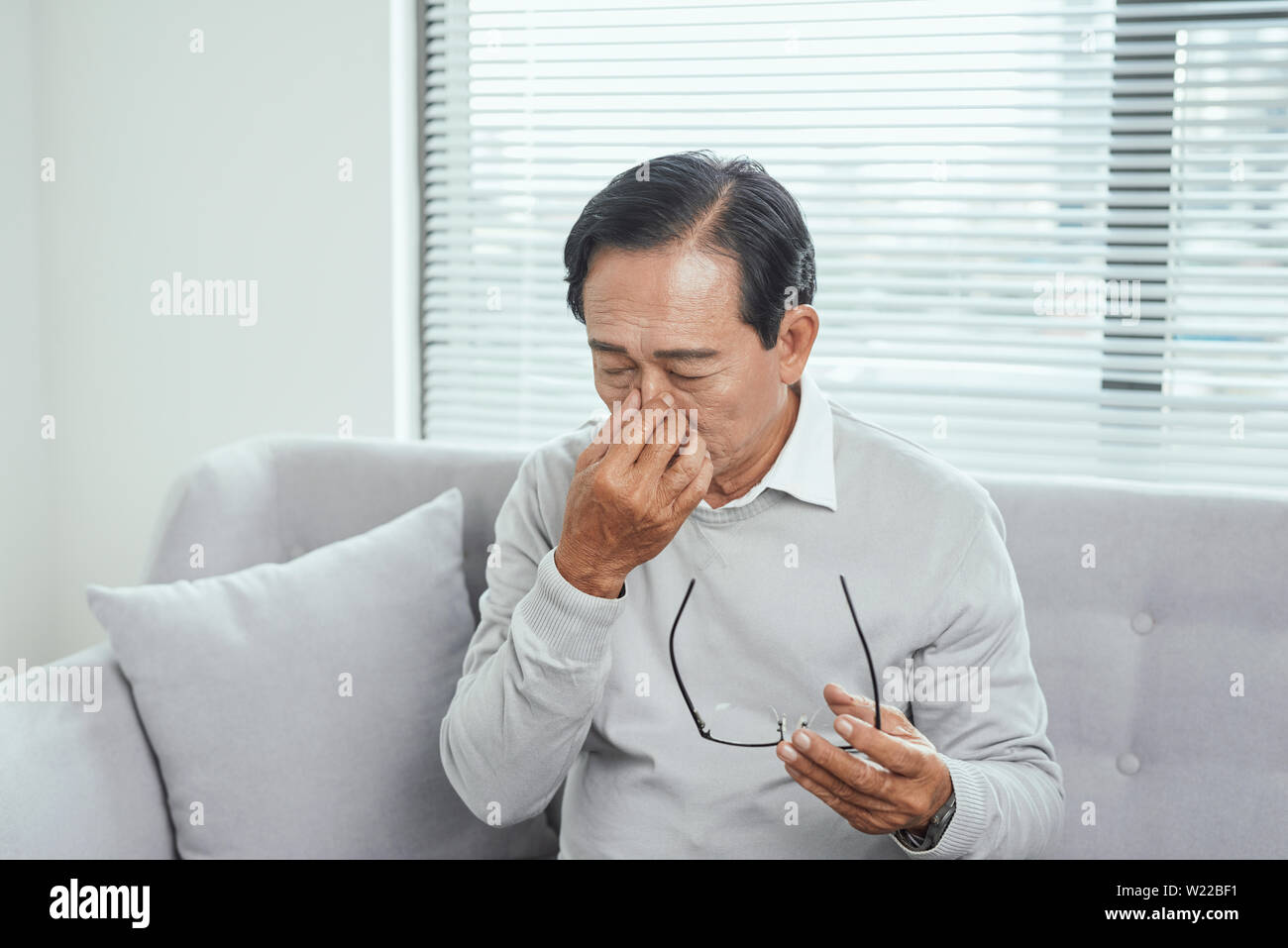 Stress, Alter und Personen Konzept - Nahaufnahme der ältere Mann in Gläser, die Kopfschmerzen und massieren Nasenbügel Stockfoto
