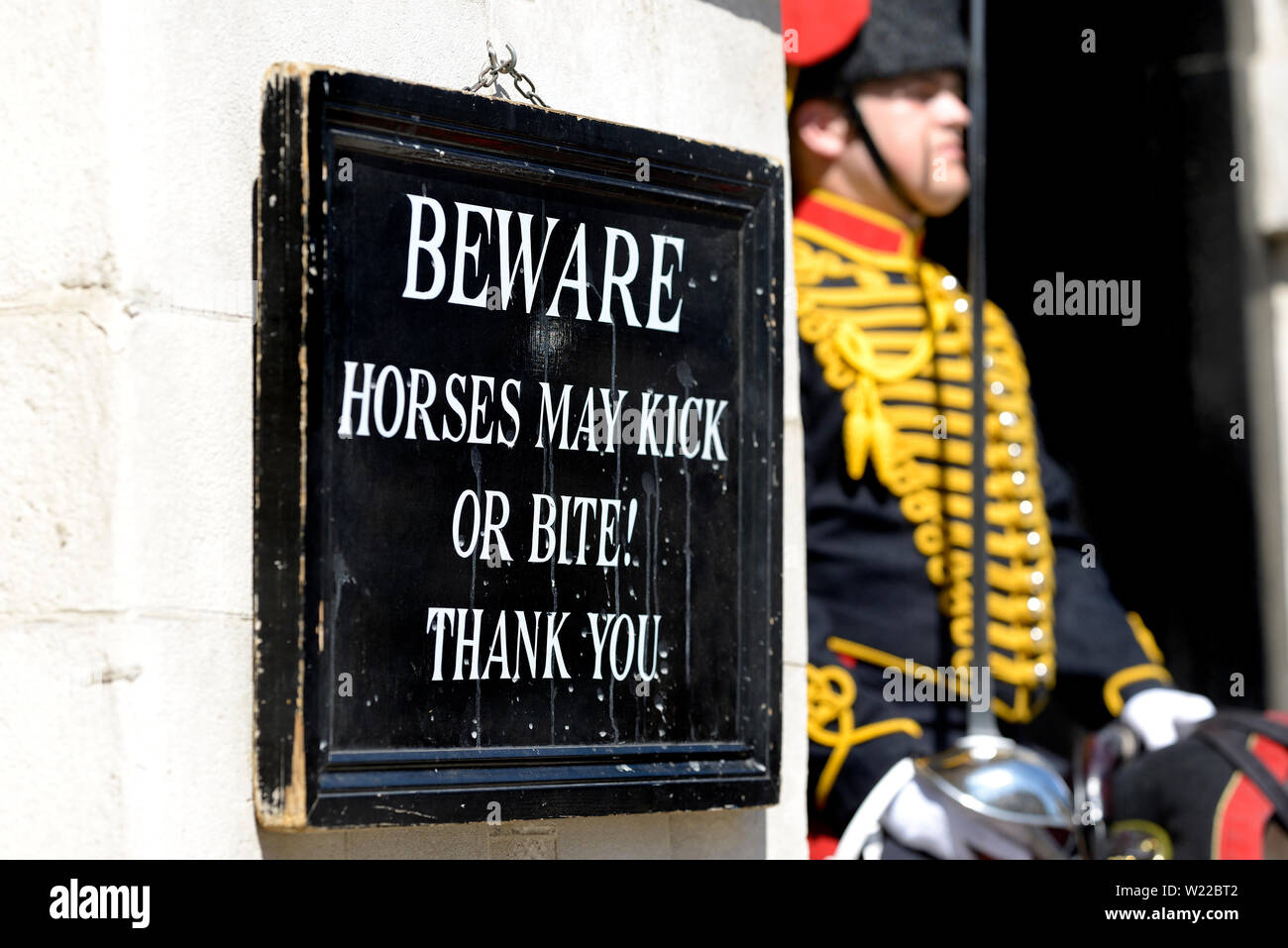 London, England, UK. Mitglied der King's Troop, Royal Horse artillery, auf Aufgabe außerhalb der Horse Guards in Whitehall neben Warnschild Stockfoto