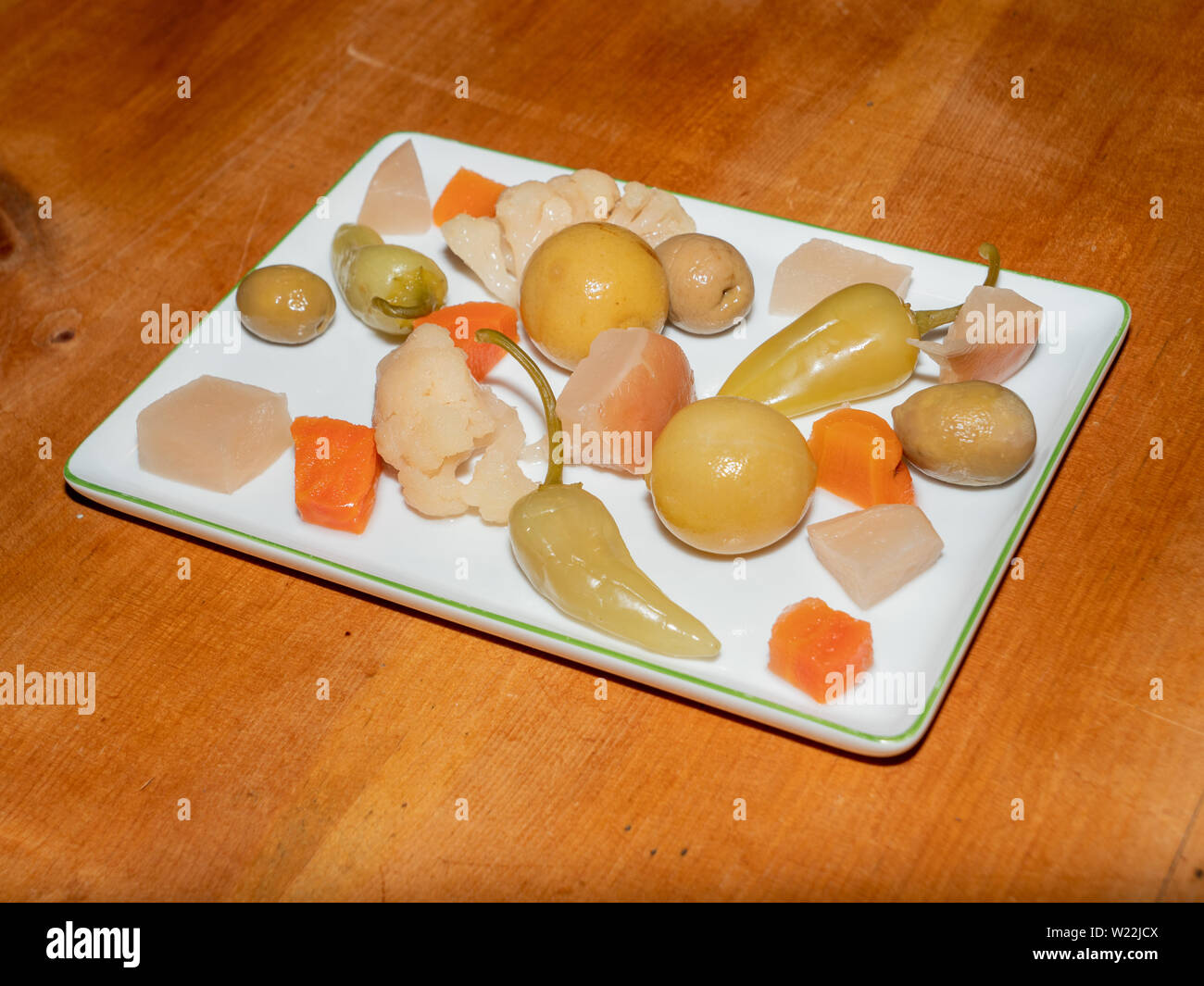 Verschiedene pikante türkische Pickles genannte tursu - Zitrone, Pfeffer, Oliven, Möhren auf einem weißen rechteckigen Platte auf einem Holz Tisch Stockfoto