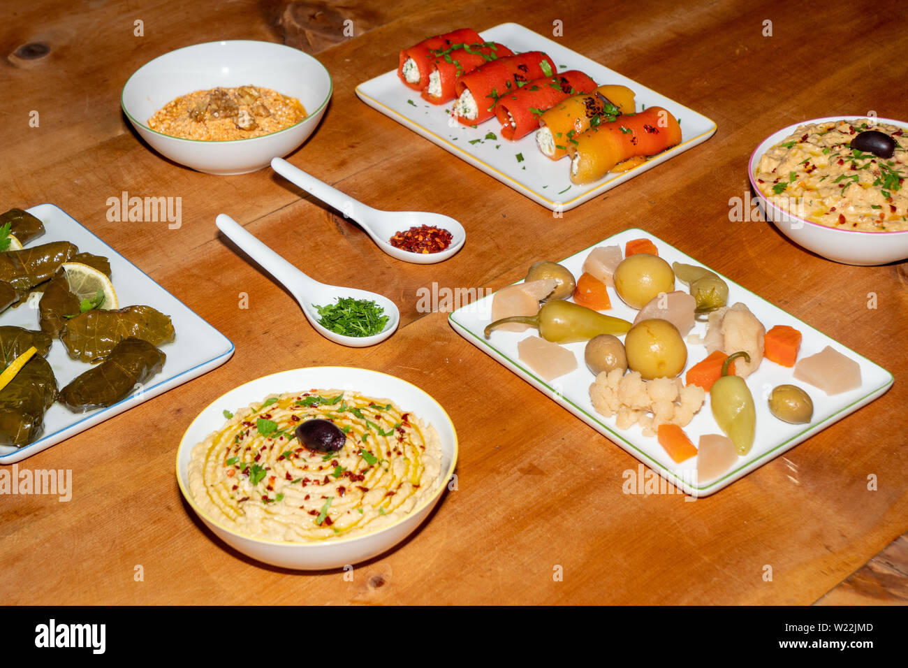 Meze sortierten Türkischen Vorspeisen auf einem Holztisch - gefüllte Weinblätter, Pfeffer Brötchen, Pickles, Hummus, Babaganoush Stockfoto