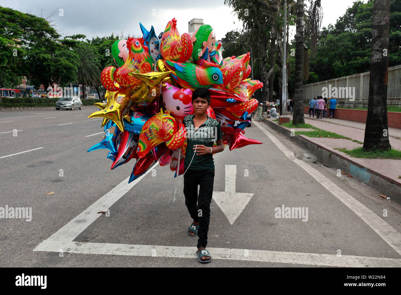 Dhaka, Bangladesch - Juli 05, 2019: Masud, kaum 13 verkauft Ballons an Manik Mia Avenue in Dhaka. Der Junge sagte, er erwirbt BDT BDT 50 10 für jeden Verkauf. Ein Stockfoto