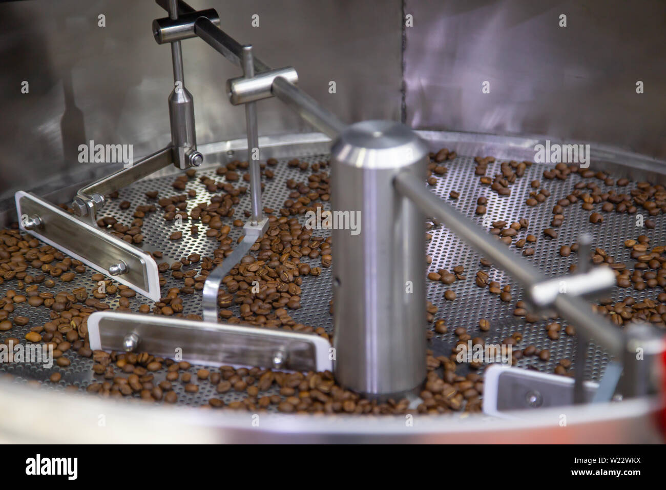 Frisch gerösteten Kaffeebohnen in einem Kaffeeröster Stockfoto