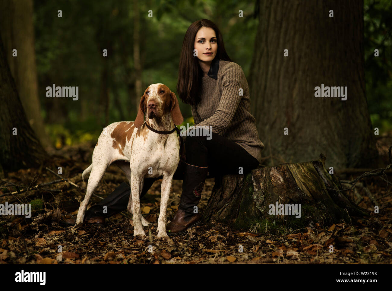 Herbst Mode. Schöne 30s Frau im Land Mode/Freizeitmode in Wäldern wandern ihre Bracco Italiano Hund. Model Release zur Verfügung. Stockfoto