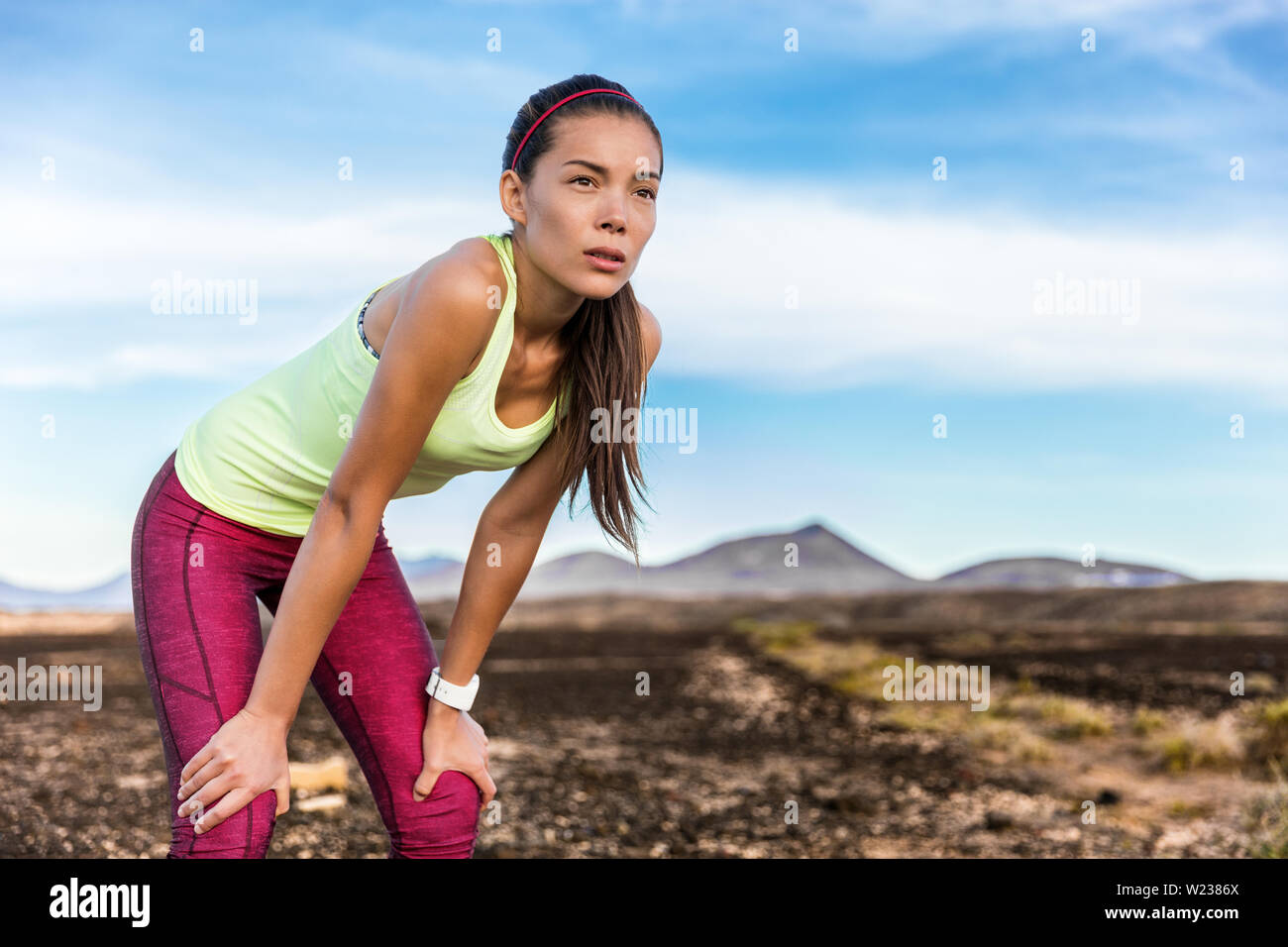 Müde Trail Running Frau am Berg Landschaft Natur Pfad mit Konzentration und Entschlossenheit auf der Suche nach Gewicht Verlust cardio Zielerreichung Herausforderung zu nehmen. Asiatische Sportarten Sportler Läufer atmen. Stockfoto