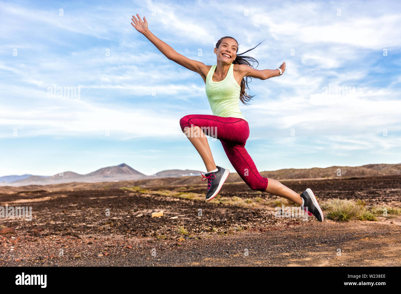 Erfolg Freiheit unbeschwerten runner Frau Spaß zu laufen. Glück, Freude, energetische Athlet Mädchen glücklich von Gewichtsverlust Zielerreichung springen lustig im Sommer outdoor Trail Natur. Fitness Motivation. Stockfoto