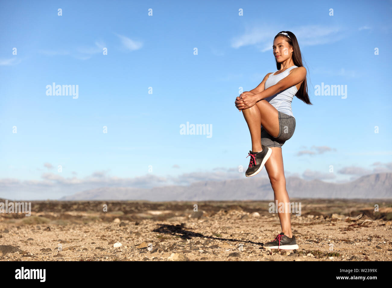 Ständigen Gluteus maximus Bein strecken. Fitness Frau, dehnen Übungen trainieren Stretching glutes Muskeln und kniesehne als Warm-up für cardio übung. Trail im Sommer im Freien Natur. Stockfoto