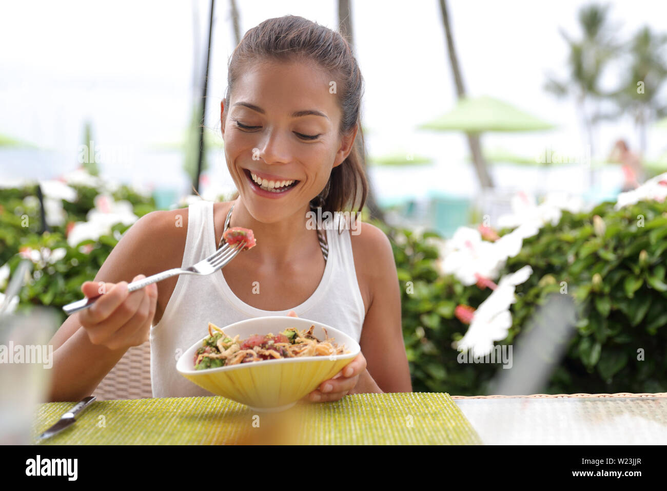 Asiatische Frau Essen einer frischen, rohen Thunfisch Teller, hawaiische lokales Essen poke Schüssel, der outdoor Tisch im Restaurant im Sommer Reisen Urlaub. Hawaii poke Schüssel essen Platte. Ahi Thunfisch hawaiische Küche. Stockfoto