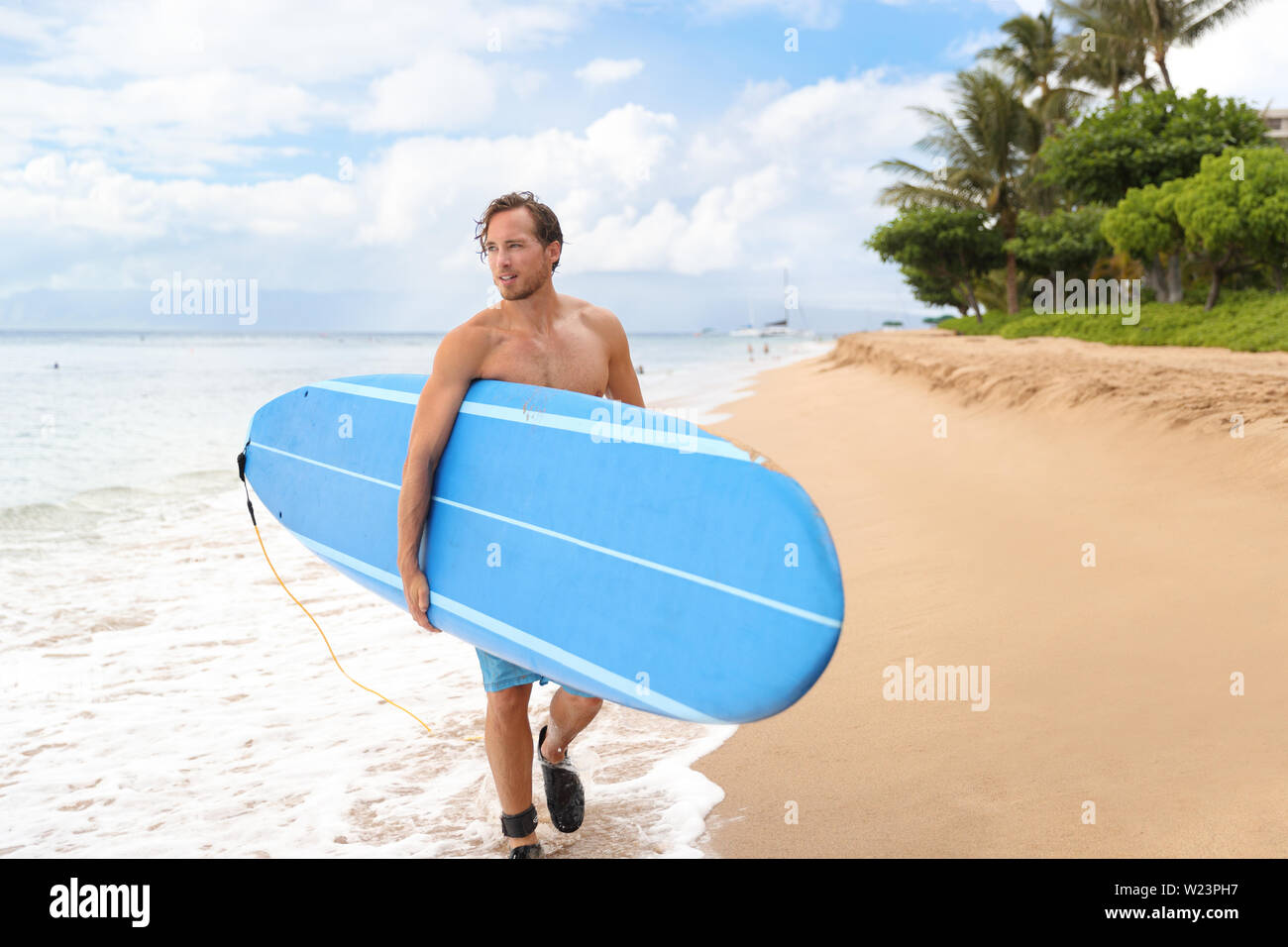 Surfer mann Surfen auf Maui Hawaii, USA. Professionelle männliche Athlet Durchführung Blue Surf Longboard gehen Für ein Surf Session am Kaanapali Beach, Hawaii Ziel. Reisen surfer Lifestyle. Stockfoto