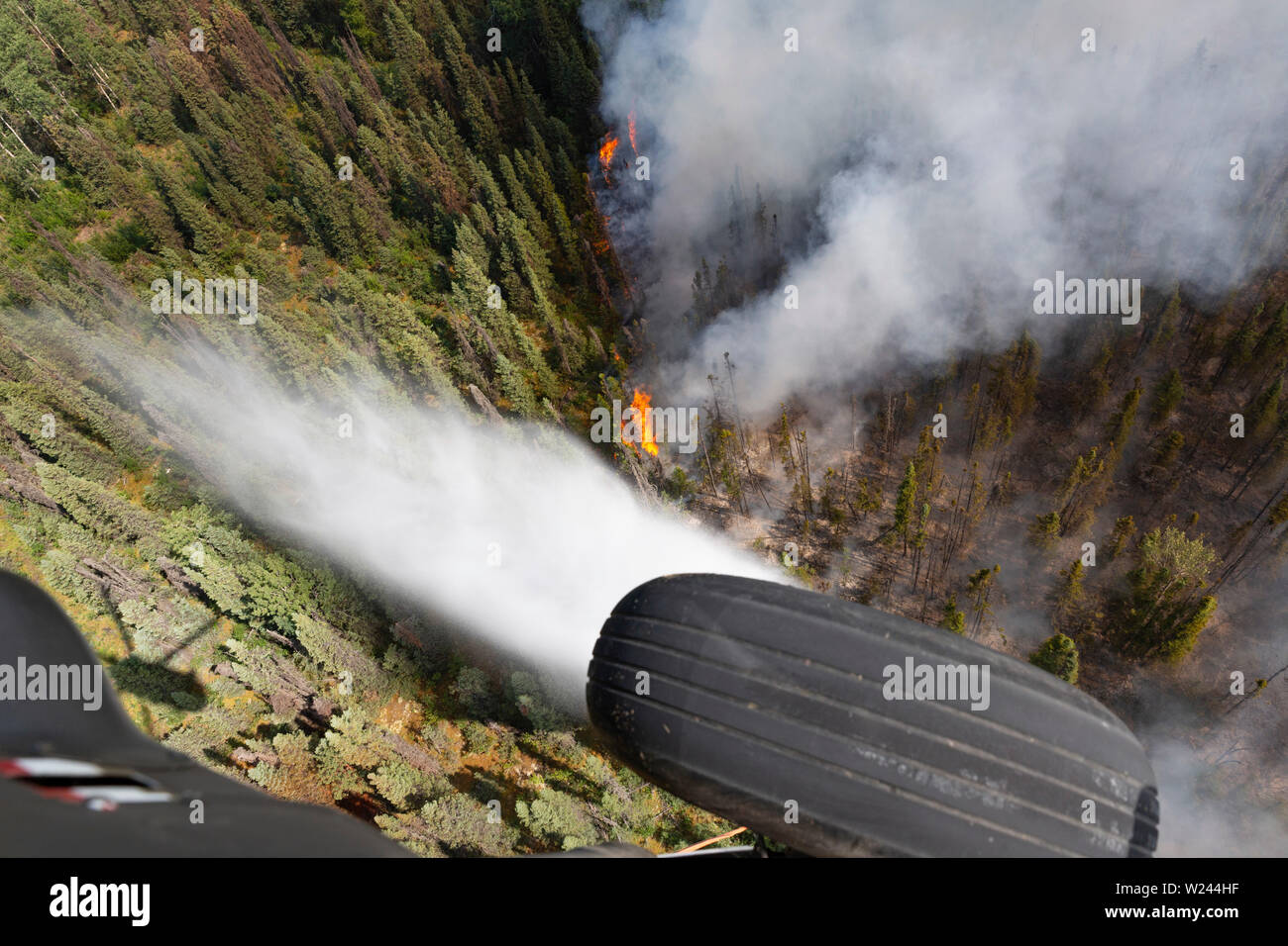 Talkeetna, Alaska. 04. Juli, 2019. Die US-Armee Alaska National Guard UH-60 Blackhawk Hubschrauber Tropfen Wasser auf ein wildfire Brennen in der Nähe von Montana Creek Juli 4, 2019 in der Nähe von Talkeetna, Alaska. Credit: Planetpix/Alamy leben Nachrichten Stockfoto