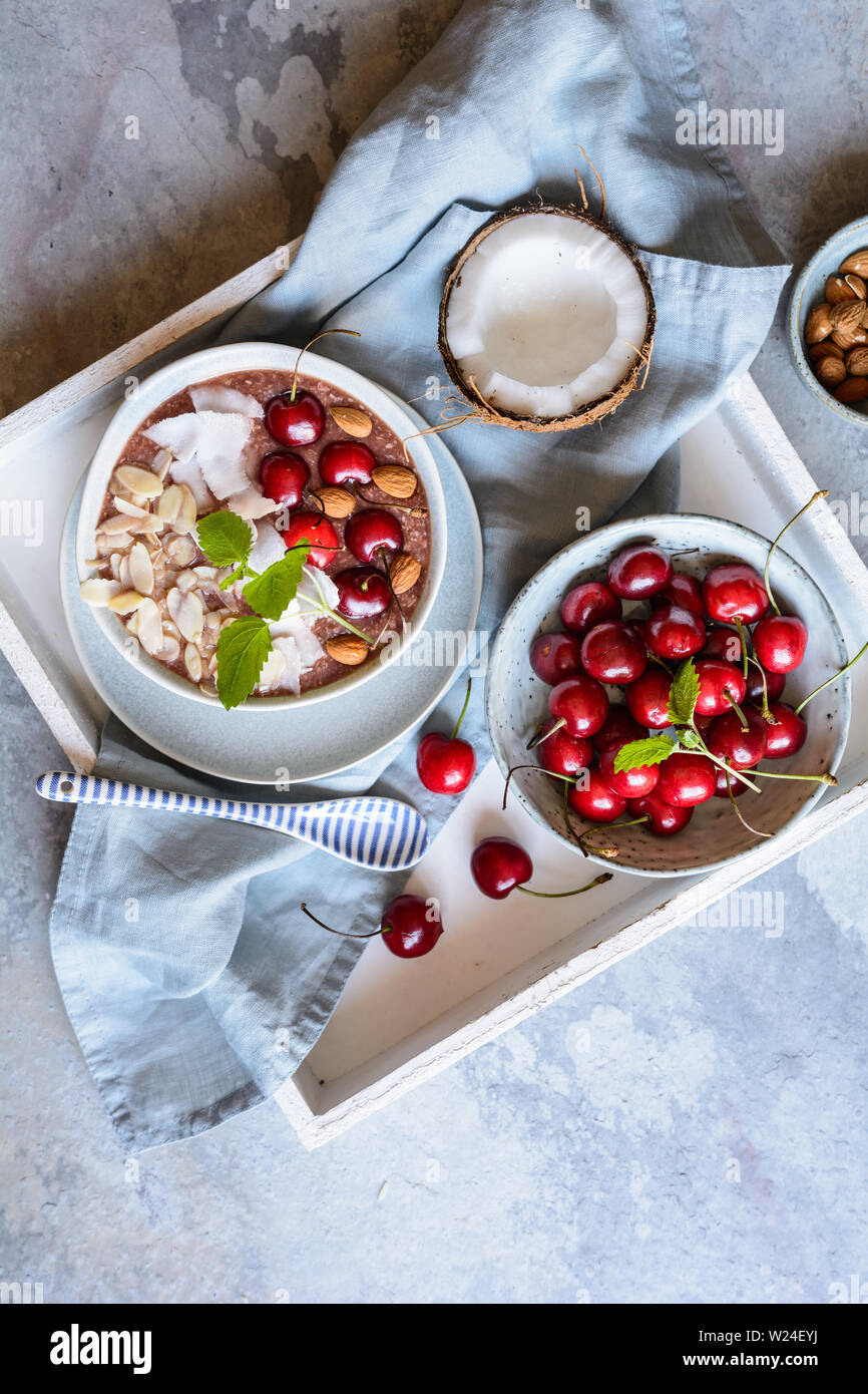 Gesunde cherry Coconut smoothie Schüssel mit Banane und Mandeln Stockfoto