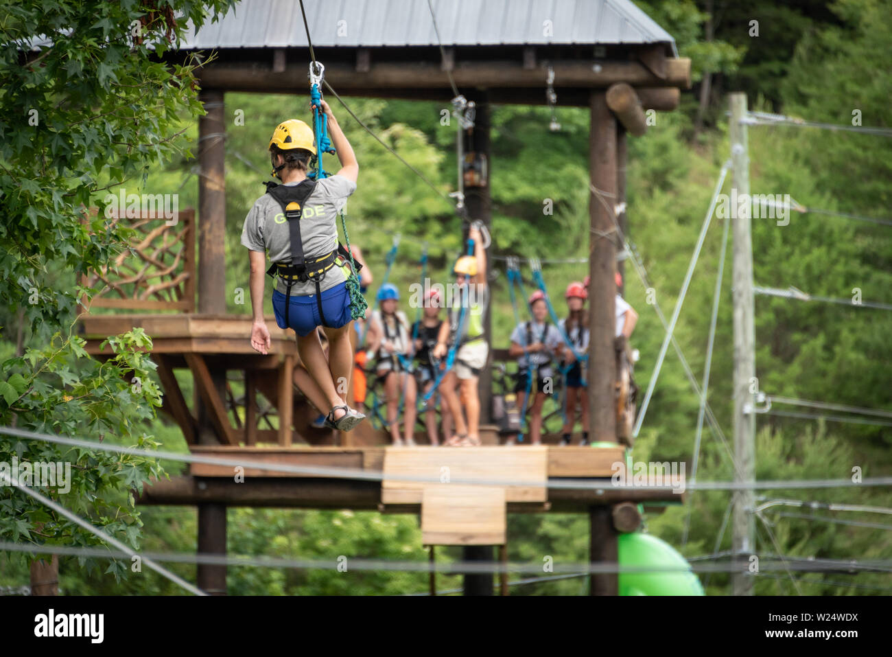 Junge Frau Führer ziplining am kühlen Fluss Abenteuer am Chattahoochee River in Helen, Georgia. (USA) Stockfoto