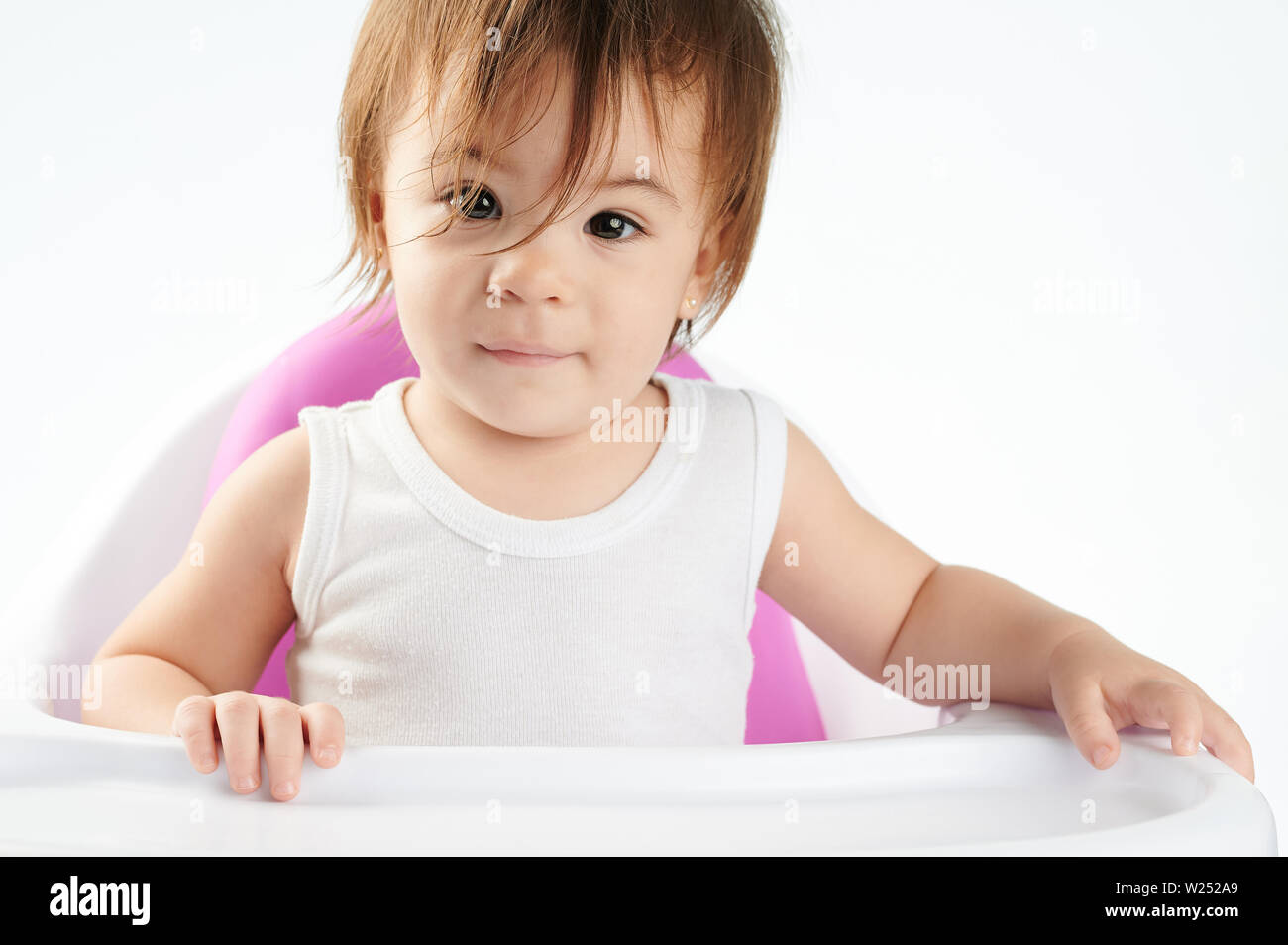 Ziemlich kaukasische Baby girl portrait Siiting auf Hoher Stuhl isoliert Stockfoto