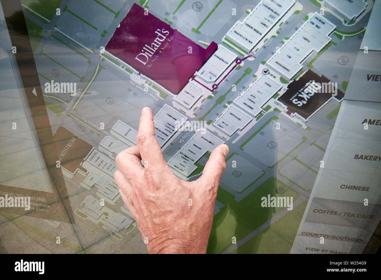 Mans hand mit Prise Bewegung auf dem Touchscreen Verzeichnis in St Johns Town Center Jacksonville Florida USA Stockfoto