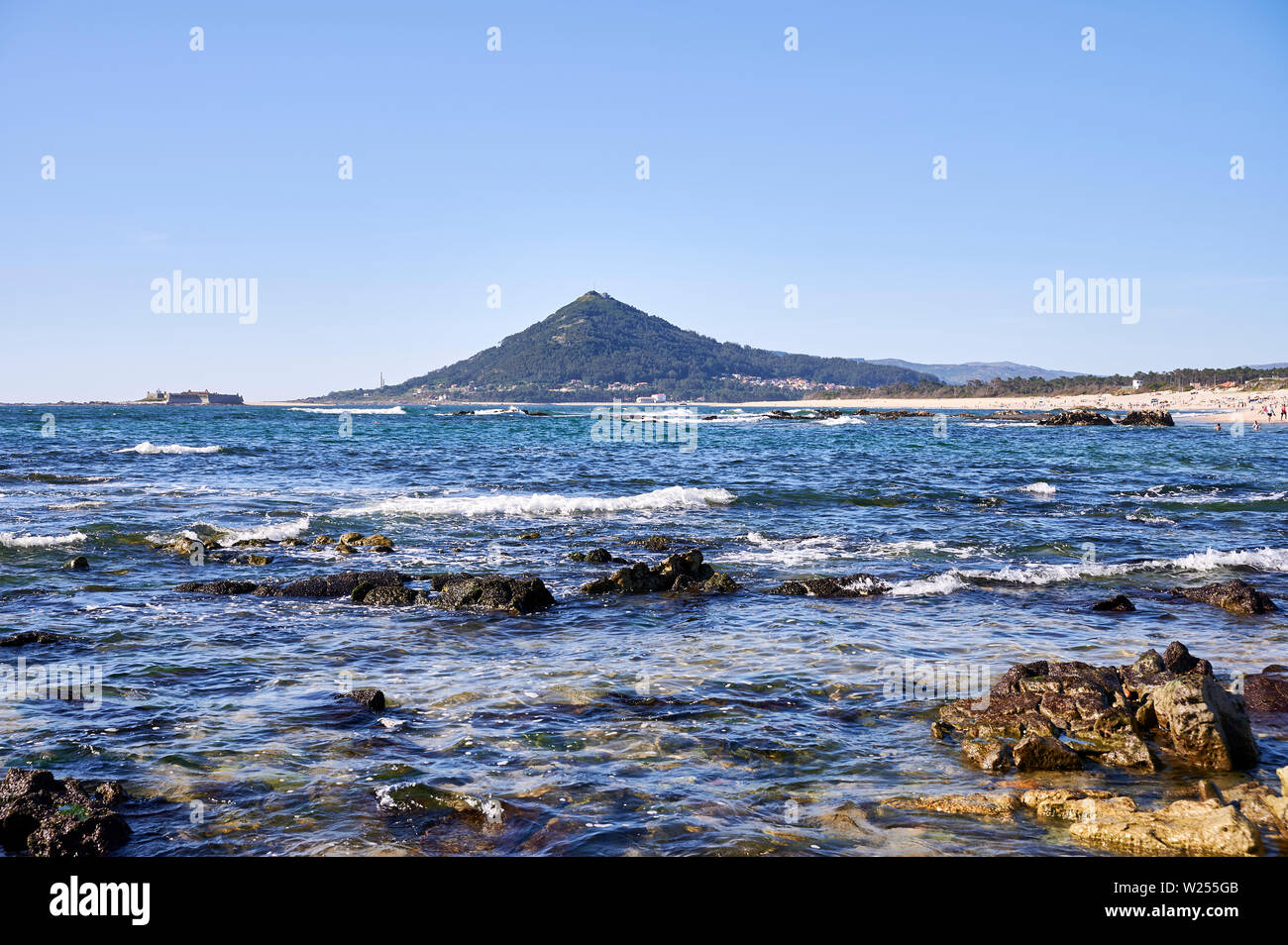 Moledo Strand an einem Frühlingstag, mit Wellen auf das Meer und die Berge im Hintergrund Stockfoto
