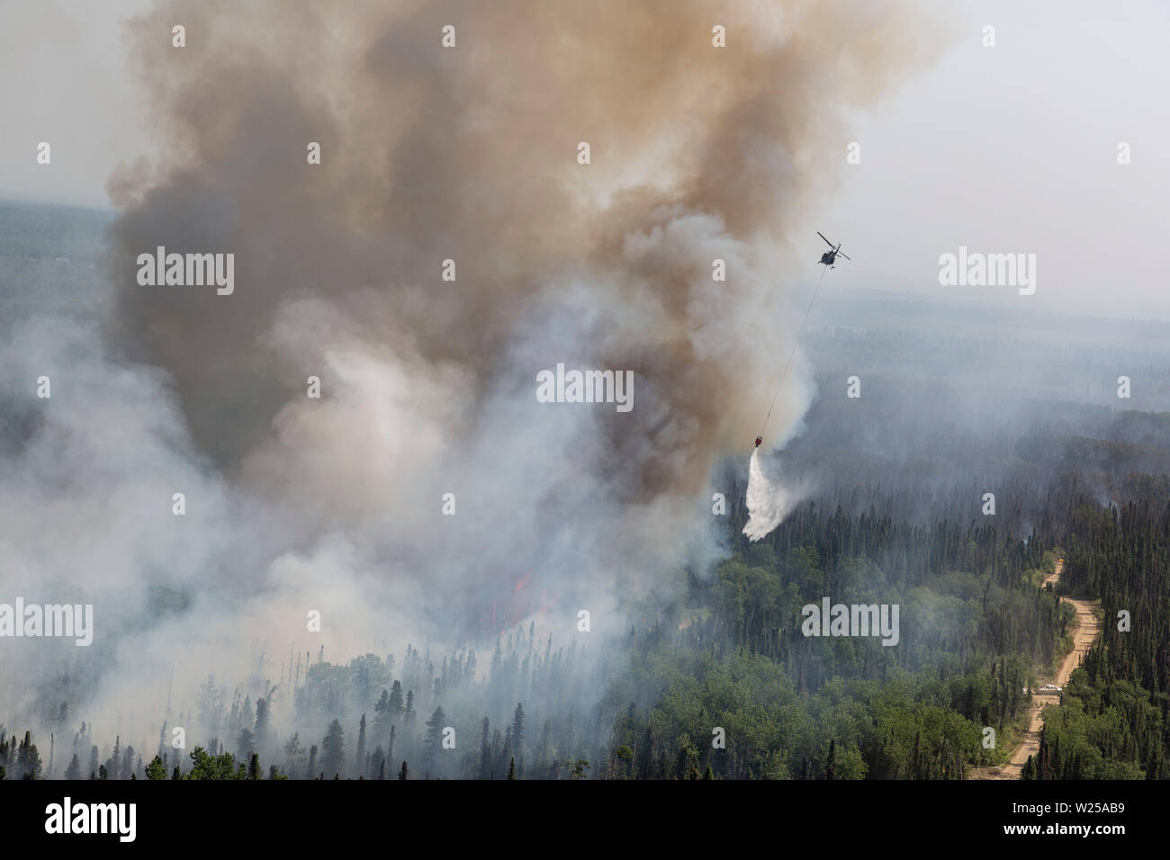 Alaska Army National Guard UH-60 Blackhawk Mannschaften von 1-207 th Aviation Arbeiten zur Unterstützung der Abteilung der Forstwirtschaft Besatzungen ein wildfire bei Montana Creek in der Nähe von Talkeetna, Alaska Juli 4, 2019 zu kämpfen. (U.S. Army National Guard Foto von SPC. Michael Risinger/Freigegeben) Stockfoto