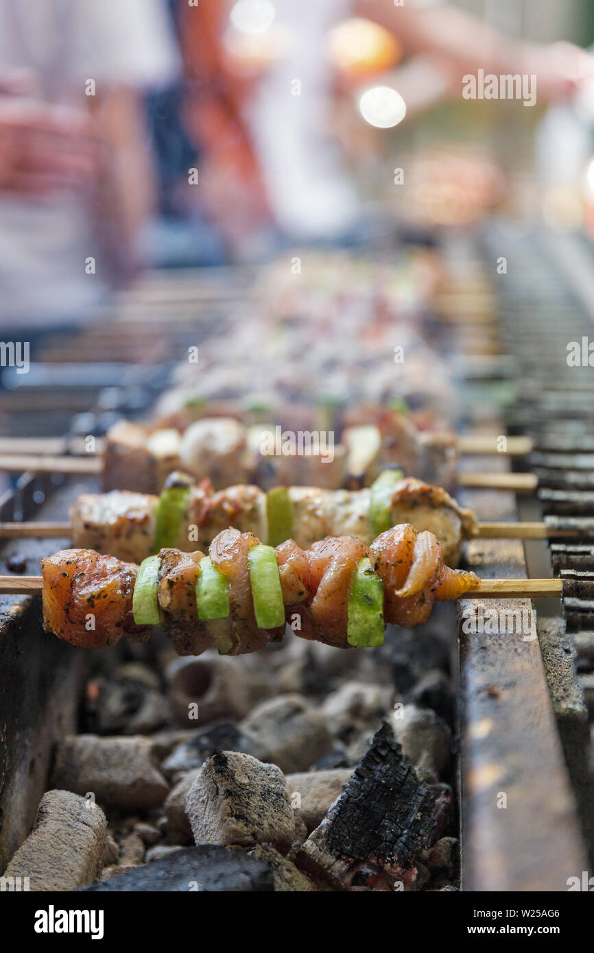 Appetitlich Schaschlik mit Putenfleisch und Zucchini gebraten am Spieß, closeup draußen. Street Food. Stockfoto