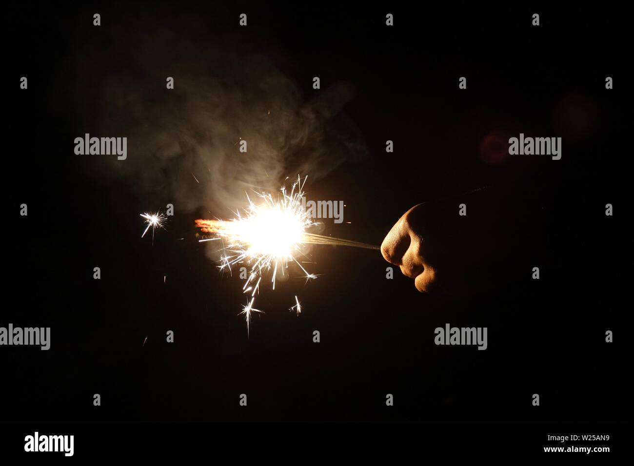 Eine Wunderkerze leuchtet und strahlt bunten Flammen und Funken. Stockfoto