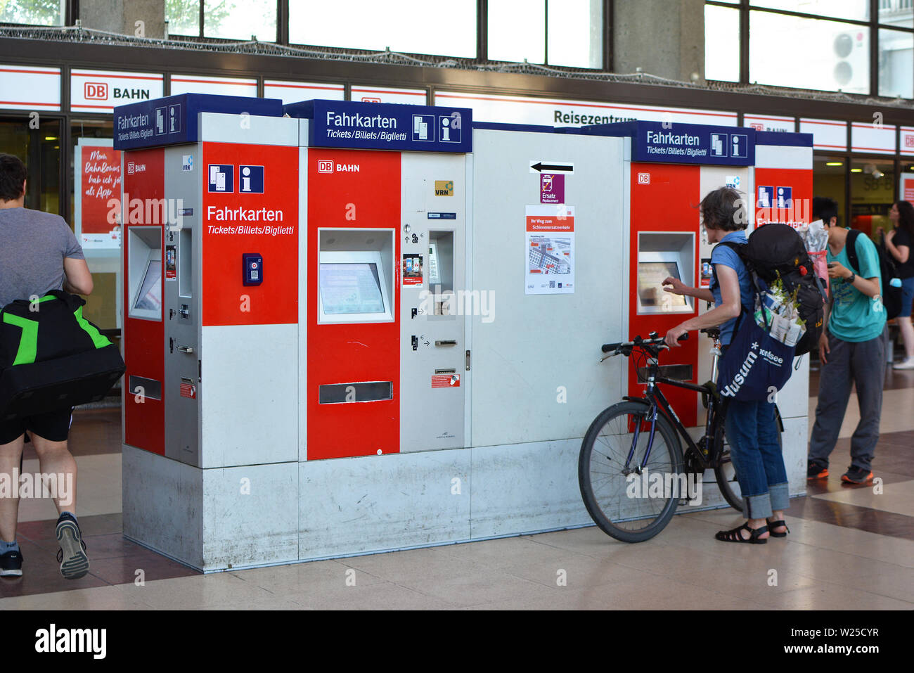 Heidelberg, Deutschland - Juni 2019: Menschen kaufen Fahrkarten am Roten Automaten am Hauptbahnhof Stockfoto