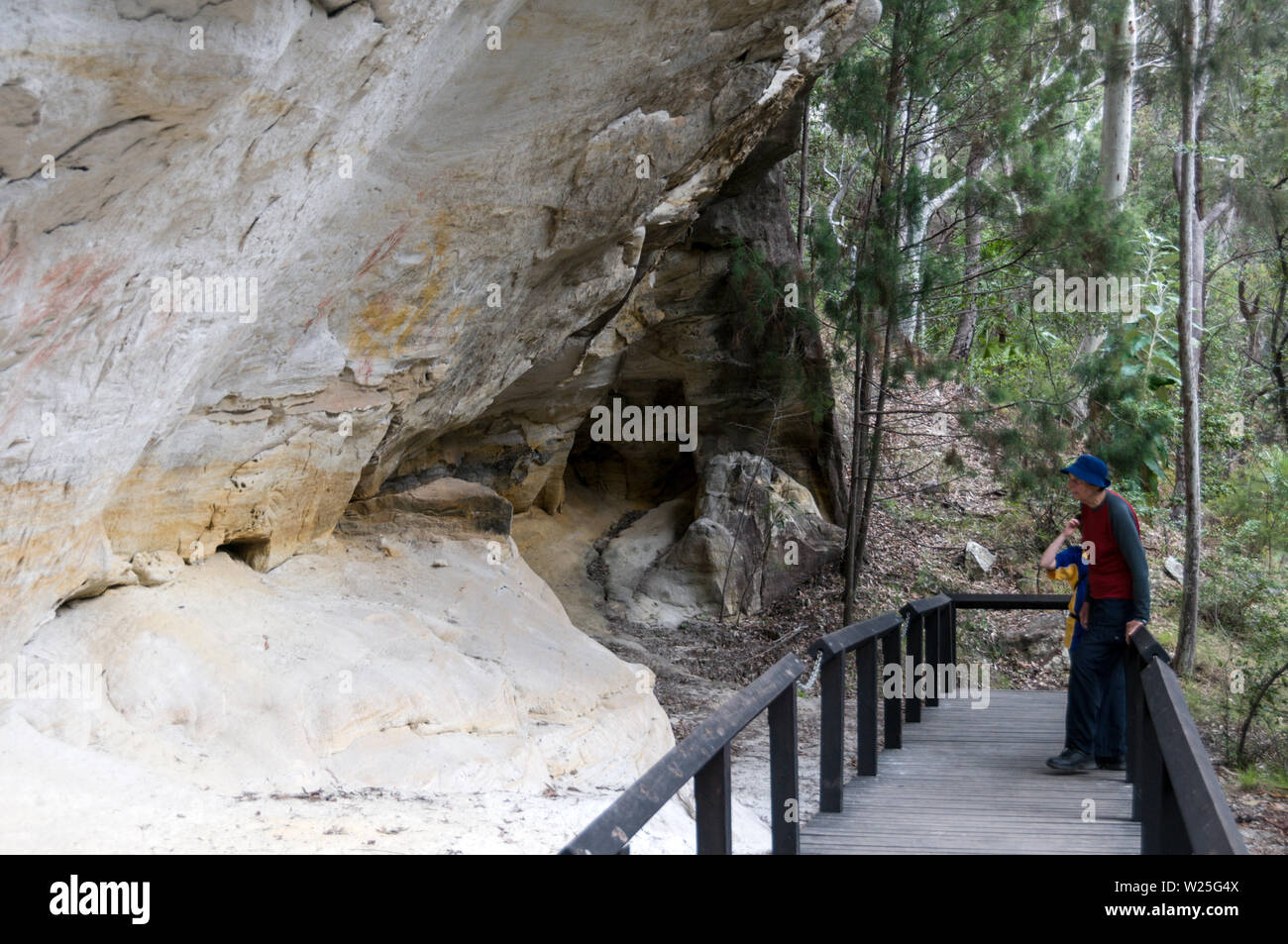 Besucher im gut erhaltenen Aboriginal Rock Art site Schablone, als die "Art Gallery" 3.650 Jahre alt auf dem weißen Sandsteinfelsen. Stockfoto