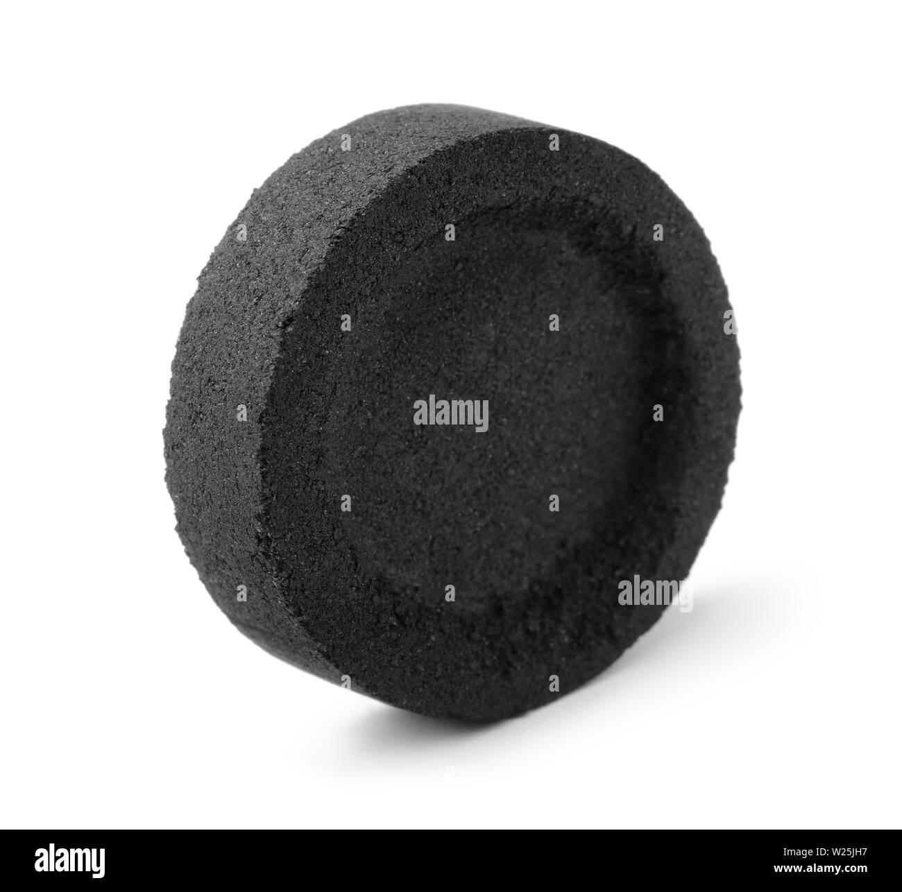 Einzelne runde Kohle Brikett isoliert auf weißem Stockfoto