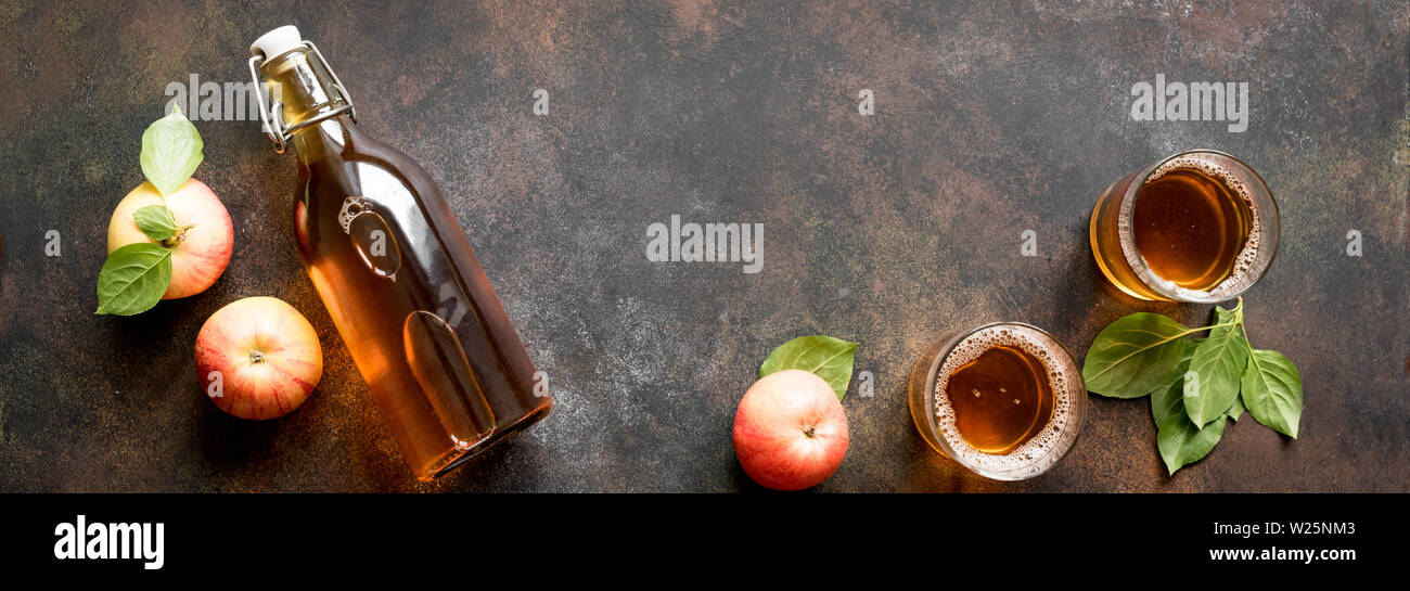 Apple Cider trinken oder vergorenen Obst trinken und organische Äpfel auf dunklen, Ansicht von oben, Banner. Gesundes Essen und Lifestyle Konzept. Stockfoto