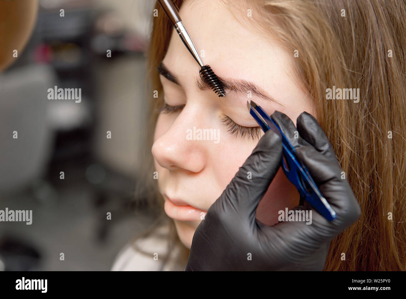 Schöne Frau Zeichnen einer Form der Augenbrauen mit kosmetischen Bürste. Make-up Artist Anwendung bis zu einem Modell Stockfoto