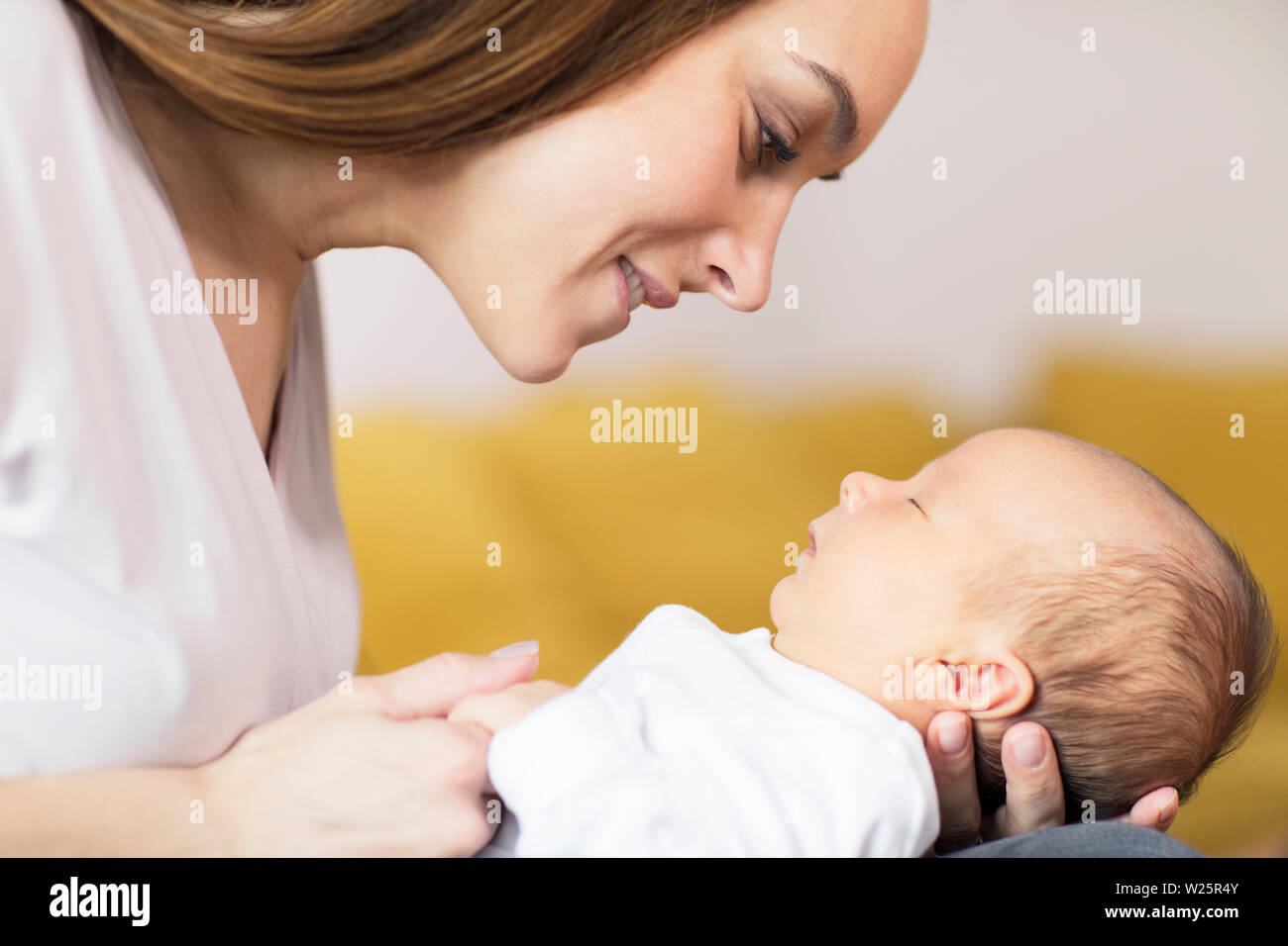 Liebevolle Mutter kuscheln Schlafen Baby Sohn auf dem Schoß zu Hause Stockfoto