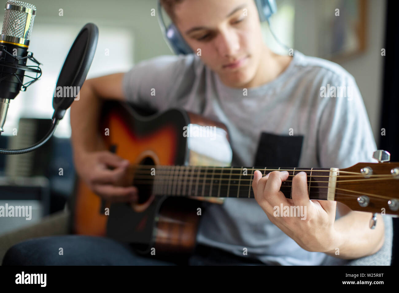 Teenager Gitarre Spielen und Aufnehmen von Musik zu Hause. Stockfoto