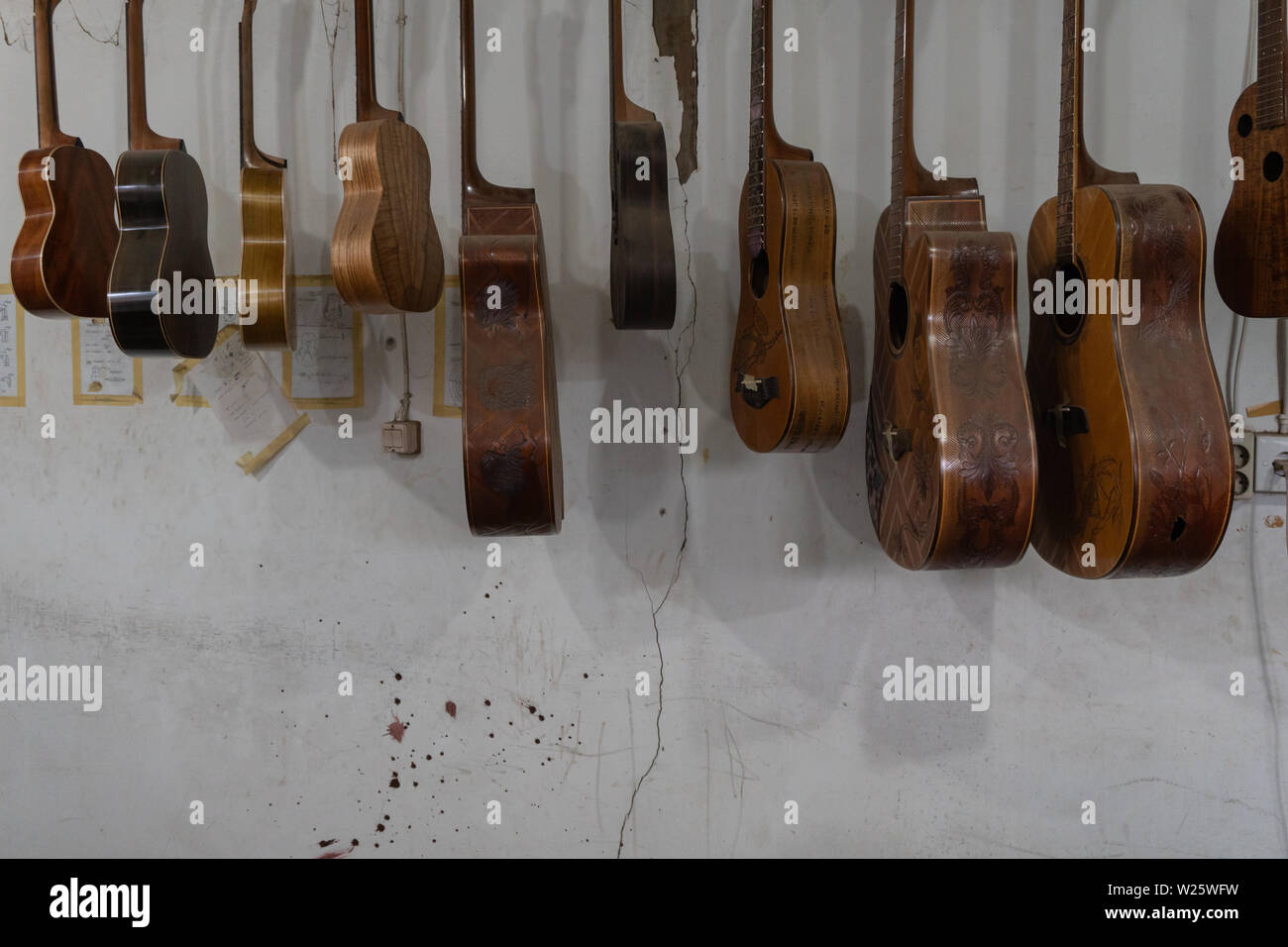 Einige unfertige customed Gitarren und Ukulelen hängen auf schlichten Zimmer im klassischen Gitarren Workshop im Besitz von I Wayan Tuges. Stockfoto