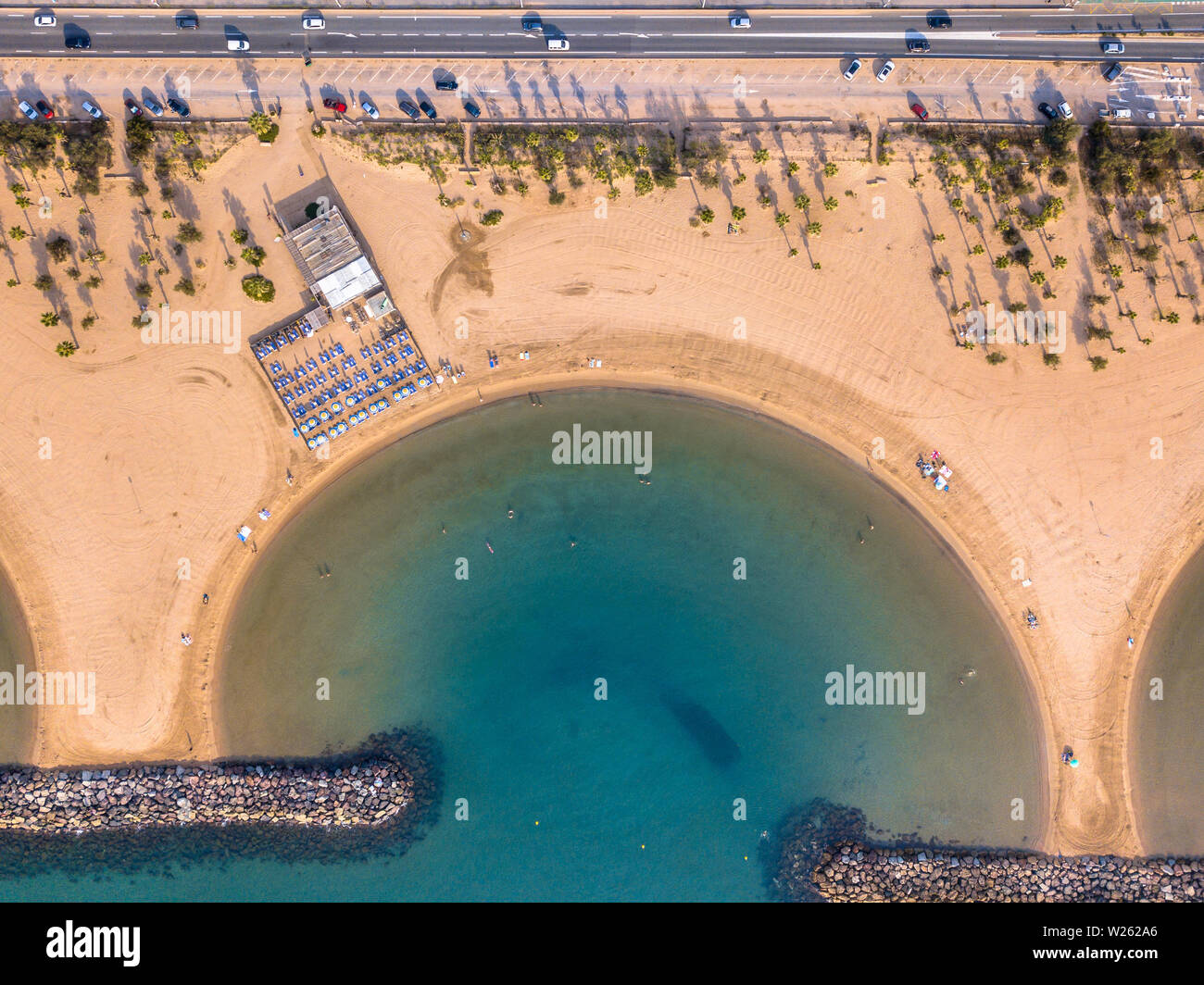 Gelb, ruhigen Strand entlang der Straße mit Parkplatz am frühen Morgen und noch nicht überfüllt an einem sonnigen Tag im Mittelmeer in Saint Aygulf in der nähe von Frejus, Côte d'Azu Stockfoto