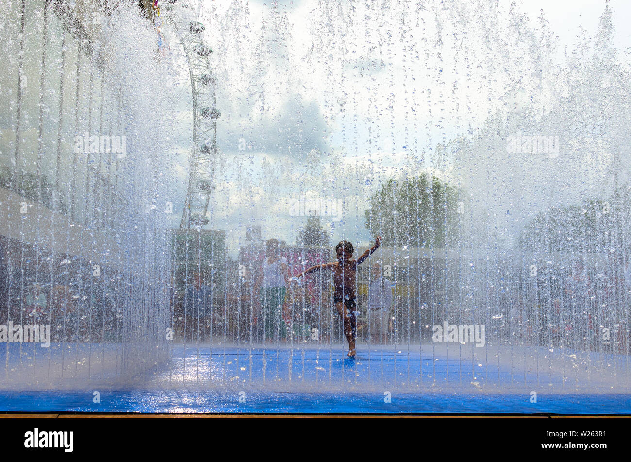 Ein Junge genießen die heißen Sommer Wetter in einem Street Fountain in London, England Stockfoto