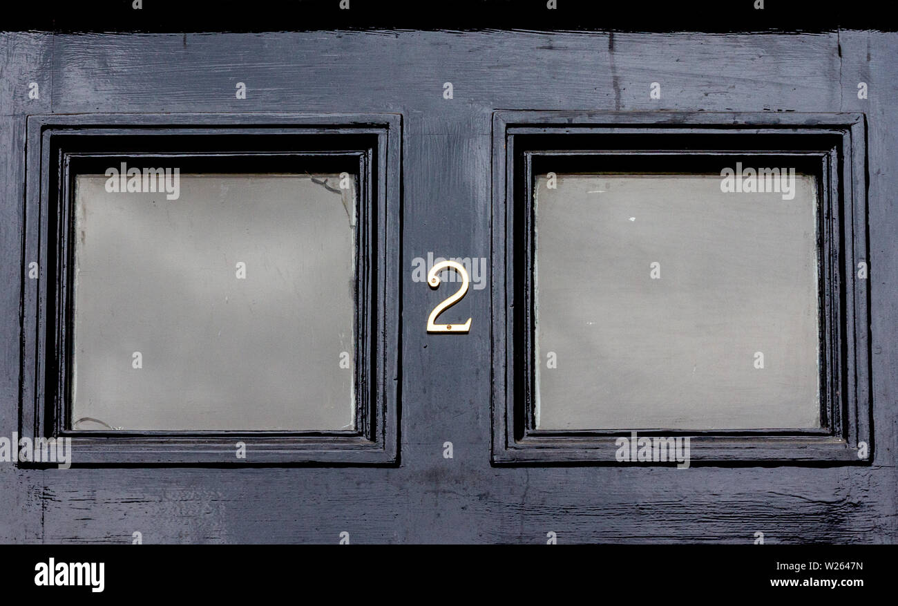 Die Hausnummer 2 mit den beiden in Metall Ziffern auf einer hölzernen Tür Stockfoto