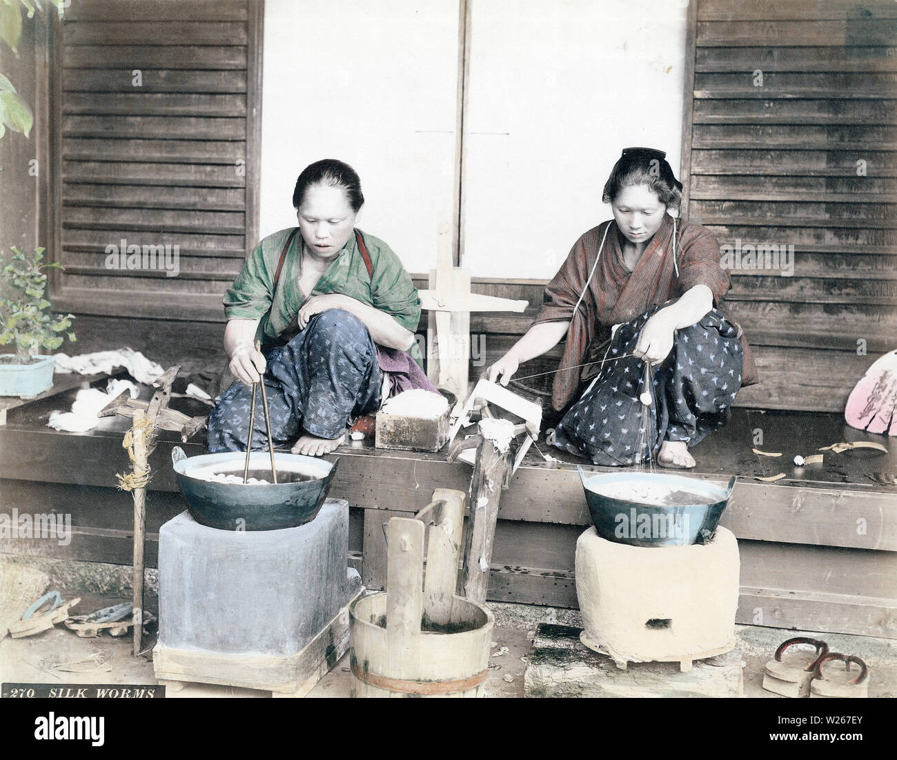 [1880s Japan-Reeling Silk] - eine Frau im Yukata und traditionelle Frisur ist Hand reeling Seide aus Kokons, während die Frau auf ihrem rechten bewegt Kokons mit Stäbchen. 19 Vintage albumen Foto. Stockfoto