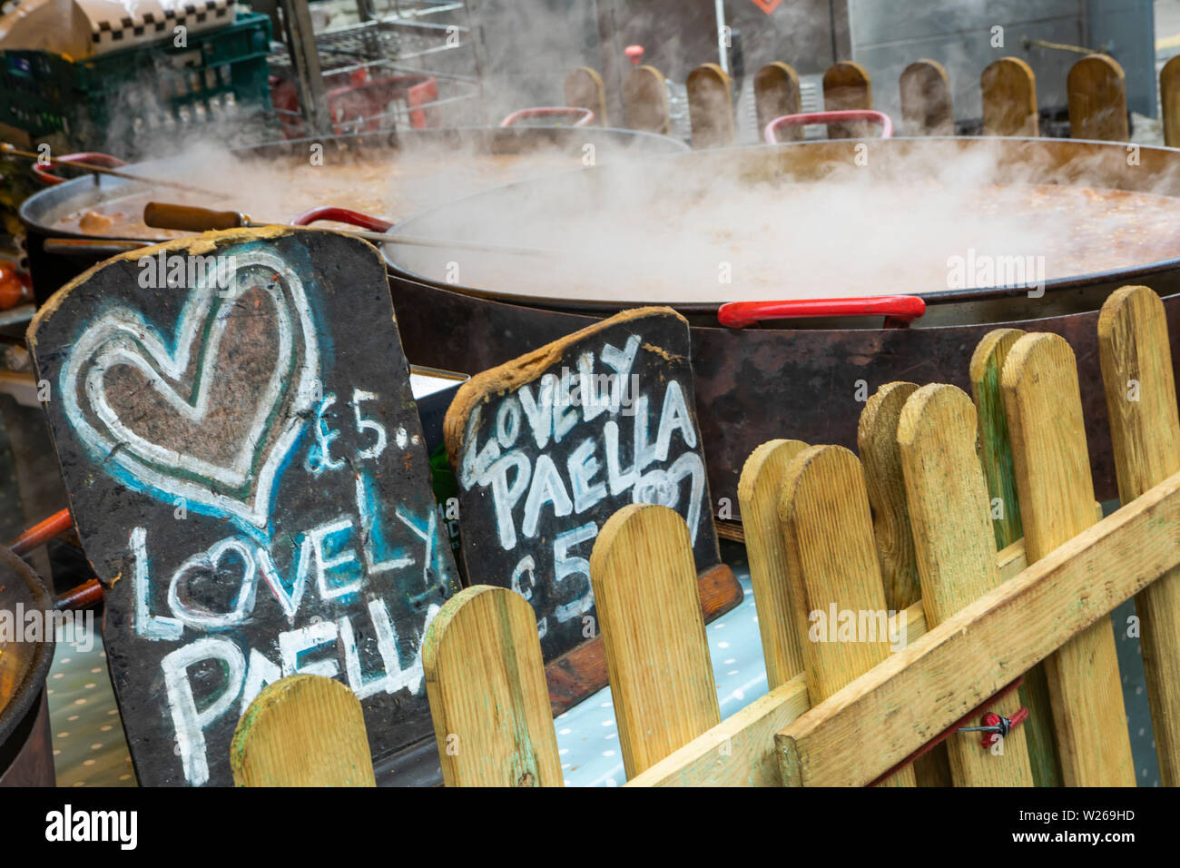 Die Paella ist Kochen in einem großen Gasherd und Dampf blubbert ist Stockfoto
