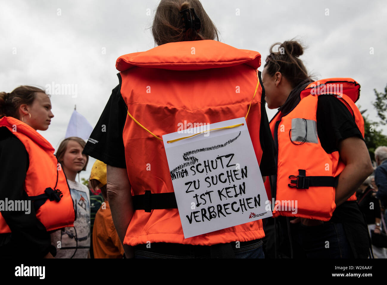 Bundesweit, Deutschland. 06 Juli, 2019. Die Teilnehmer an der Demonstration von der Seebrücke Organisation Im Bundeskanzleramt sind Schwimmwesten und ein Schild mit den Worten des Eeking Schutz ist nicht ein Verbrechen". Credit: Paul Zinken/dpa/Alamy Leben Nachrichten Quelle: dpa Picture alliance/Alamy leben Nachrichten Stockfoto