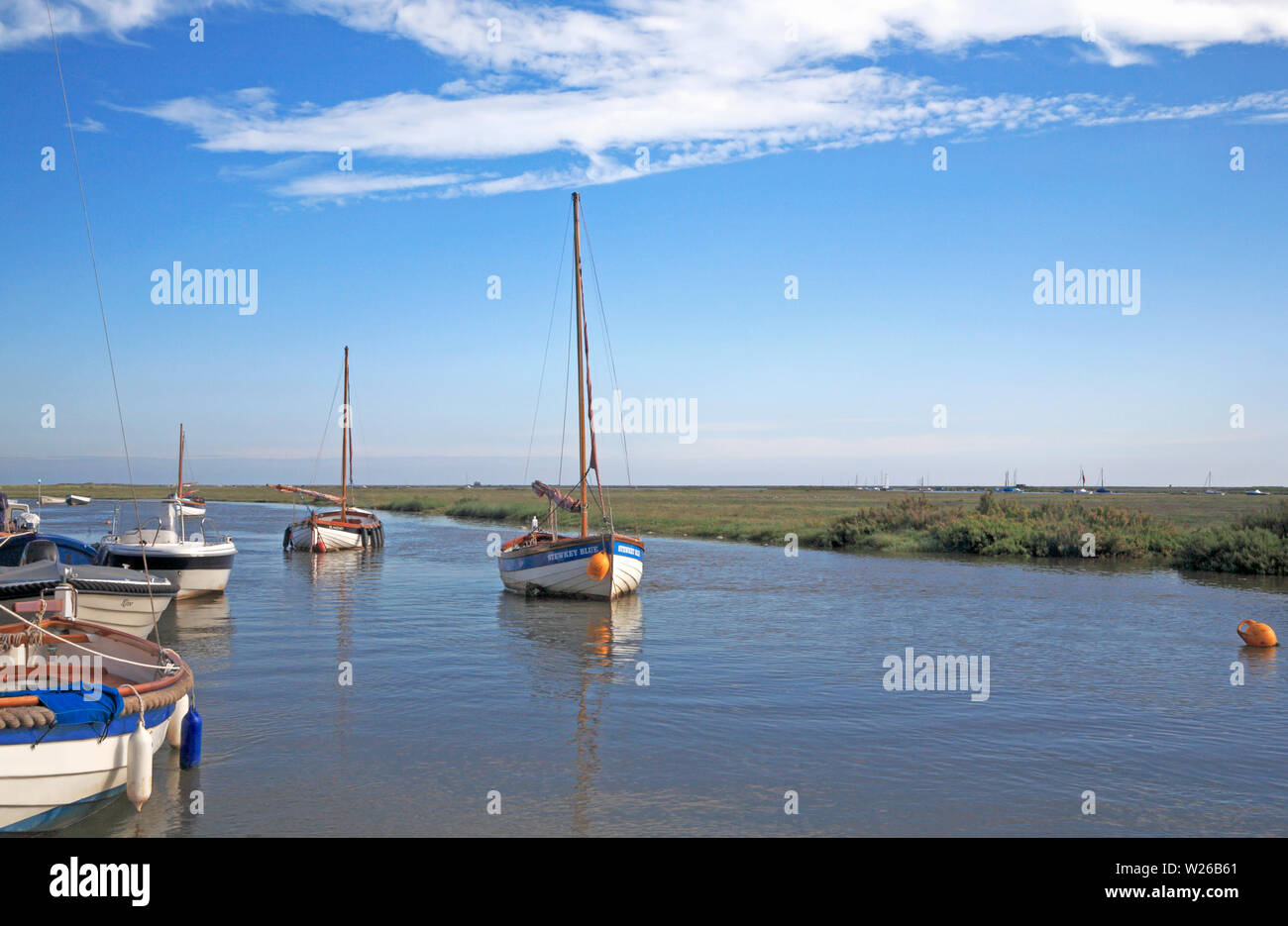 Boote und bei hohem Wasser verankert im Kanal westlich des Hafens in North Norfolk bei Blakeney, Norfolk, England, Vereinigtes Königreich, Europa. Stockfoto