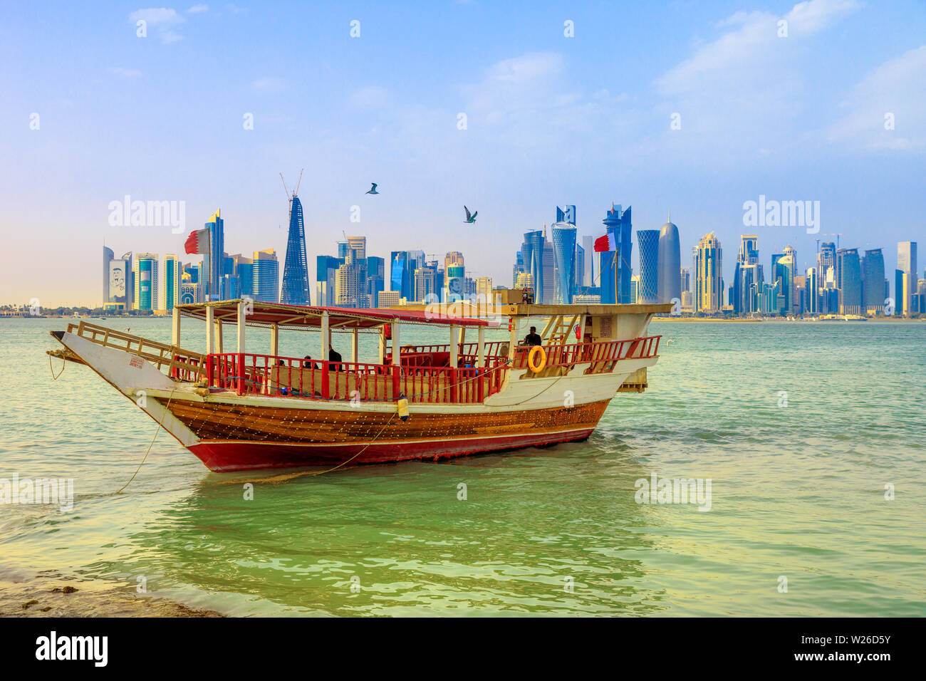 Doha, Katar - Februar 23, 2019: traditionelle Dhow und die Küste von Doha West Bay Skyline im Hintergrund mit Qatar International Exhibition Centre, Doha Stockfoto