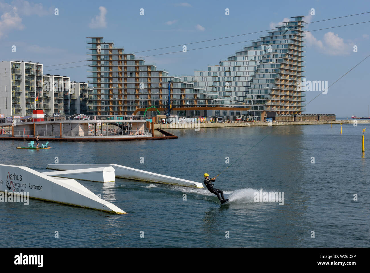 Aarhus, Dänemark - 19 Juni 2019: Mann Wakeboarding vor der modernen Wohngegend in Aarhus in Dänemark Stockfoto