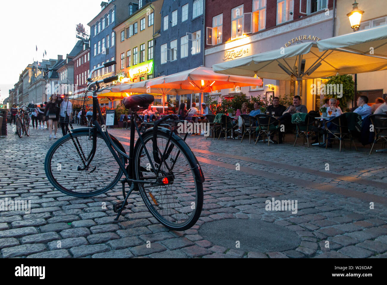 Ein geparktes Fahrrad auf den gepflasterten Straßen von Kopenhagen in Dänemark Stockfoto