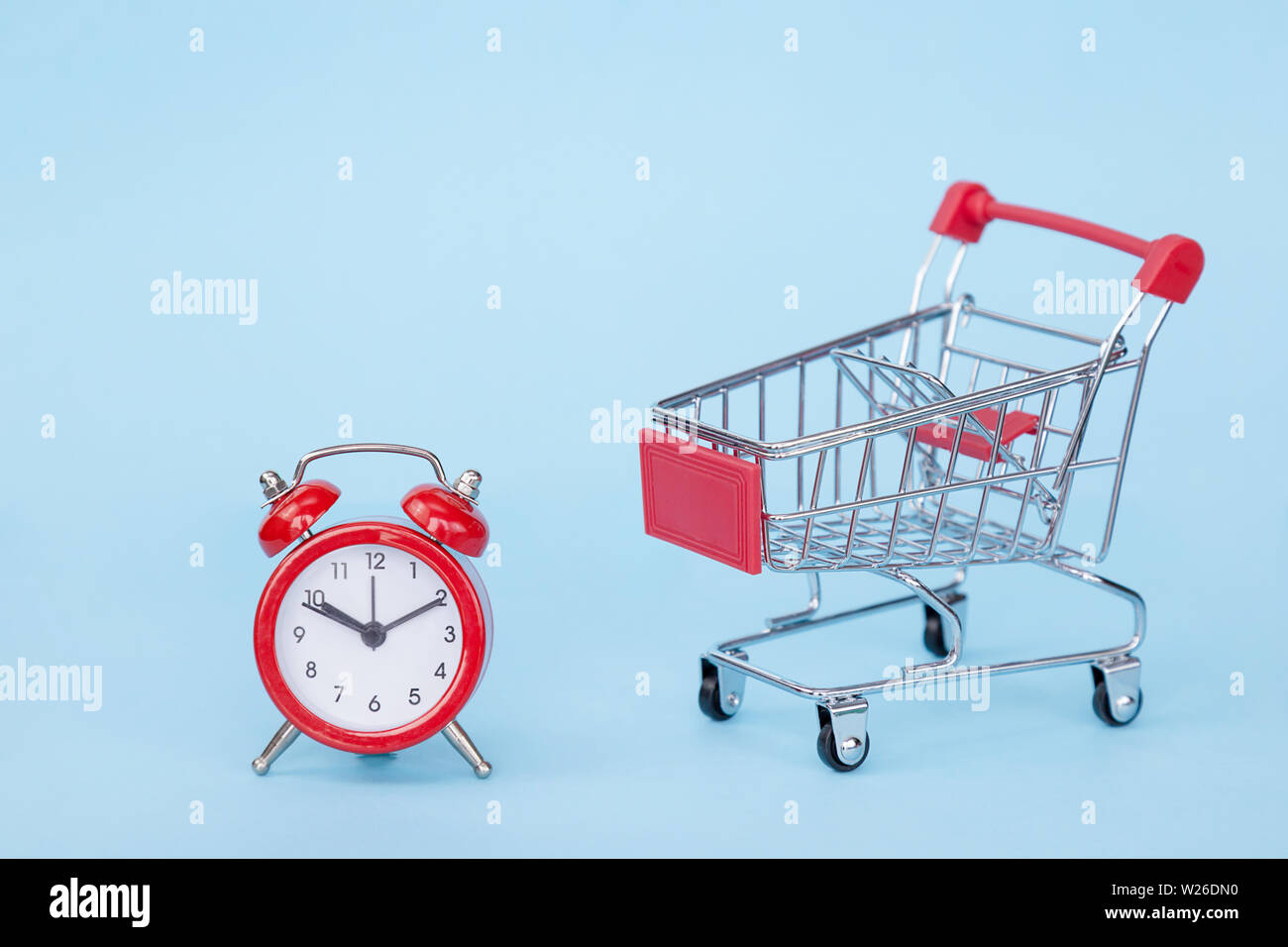 Weihnachten Geschenke und Wecker in einem Supermarkt Trolley auf blauem Hintergrund mit Freiraum für Text Stockfoto
