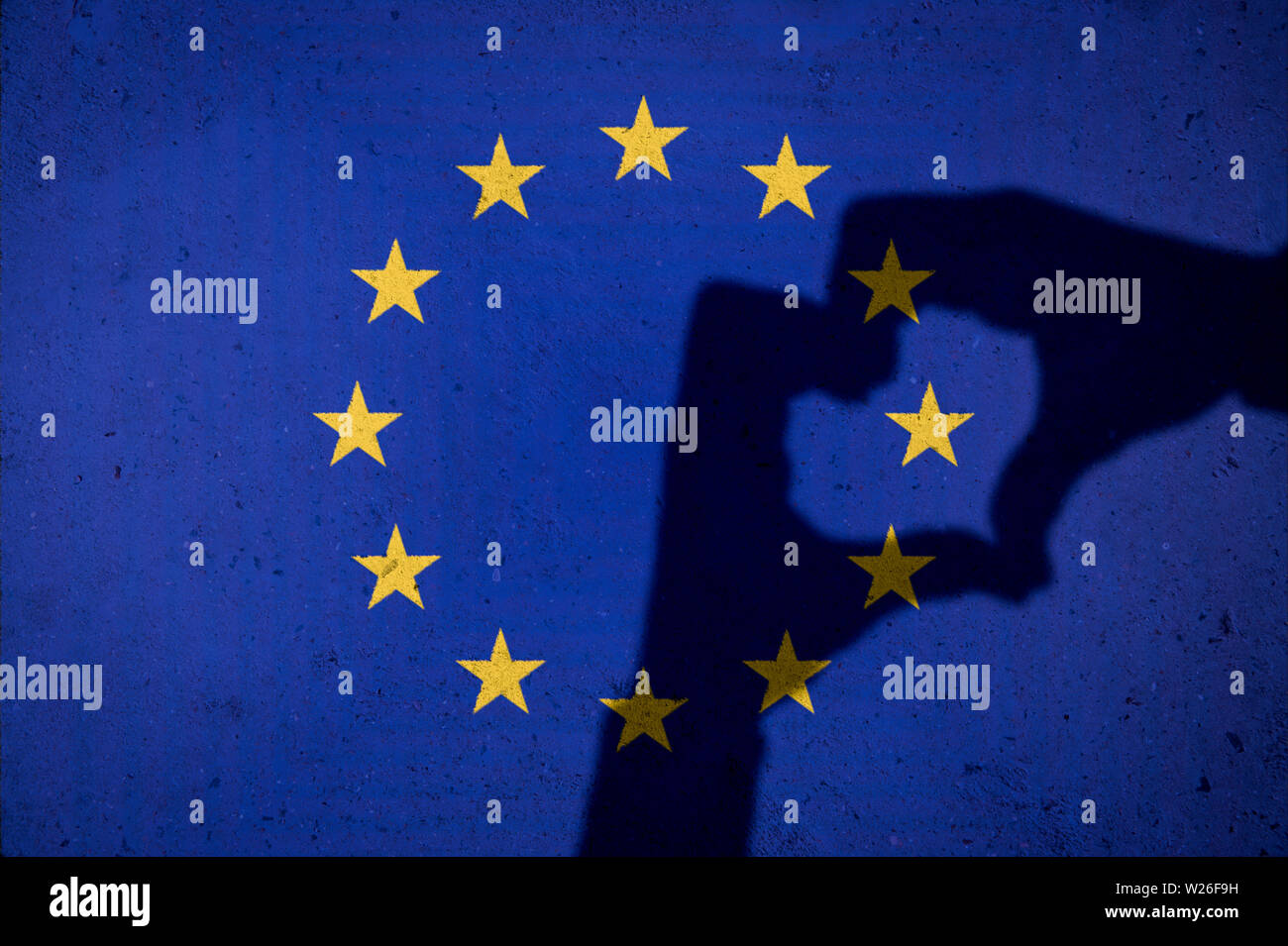 Hände, die ein Herz Schatten auf grunge EU Europäische Union Flag auf strukturierte Betonwand Hintergrund Stockfoto