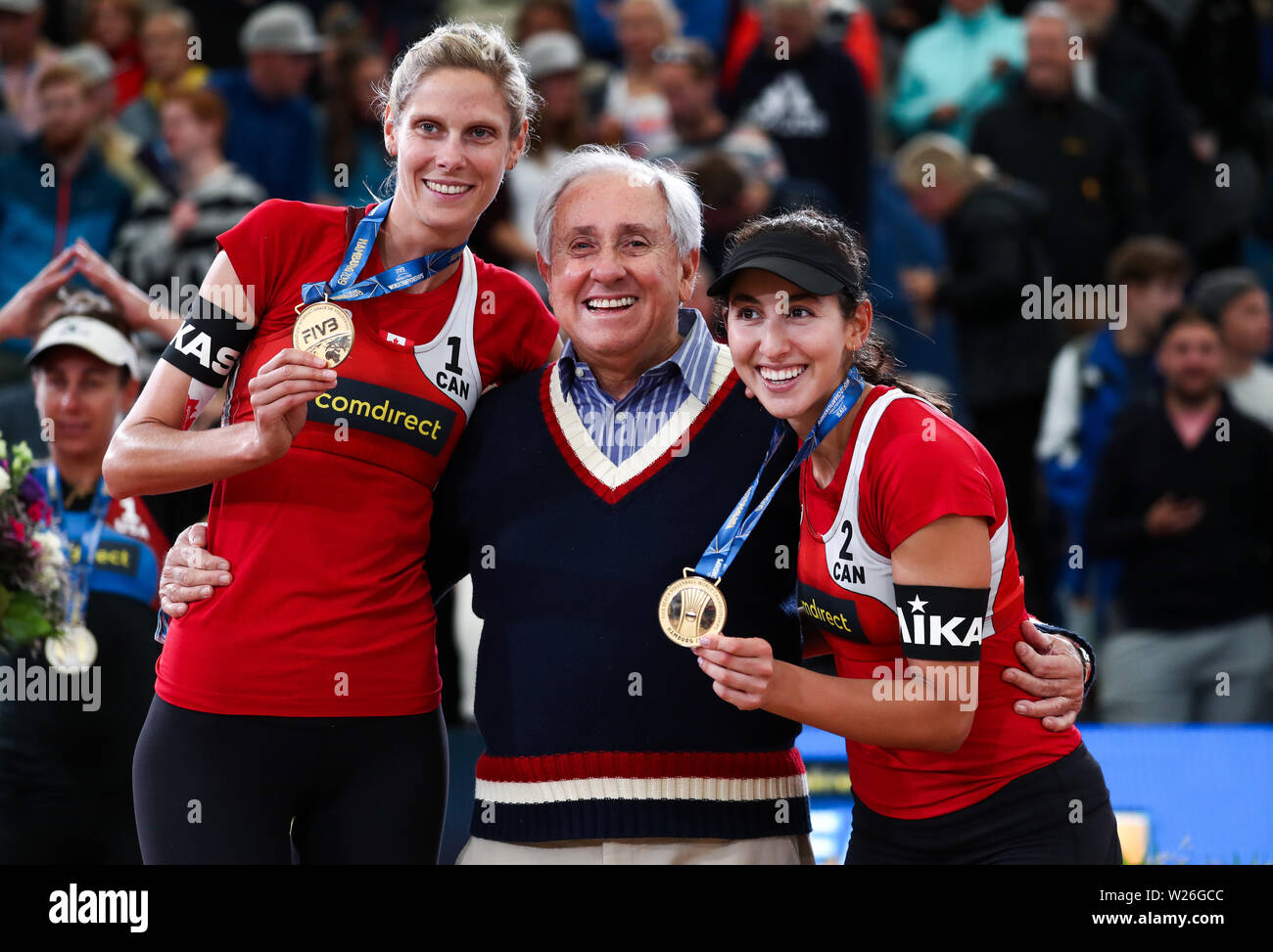 Hamburg, Deutschland. 06 Juli, 2019. Beachvolleyball, Weltmeisterschaft, in Schönried Stadion: Final, Frauen, Klineman/Ross (USA) - Pavan/Melissa (Kanada). Melissa Humana-Paredes (r) und Sarah Pavan stand mit Ary da Silva Graca Filho (M), Präsident der Welt Volleyball Federation (Fivb) auf dem Centre Court nach der Preisverleihung. Credit: Christian Charisius/dpa/Alamy leben Nachrichten Stockfoto