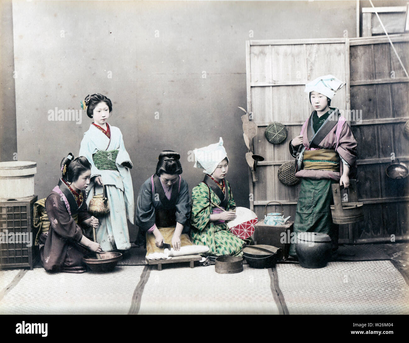 [1890s Japan - Japanische Frauen kochen] - In diesem Studio Foto der täglichen Küche, vier Frauen im Kimono typisch japanische Küche Aufgaben zeigen, die Frau auf der linken Seite ist das Schleifen etwas in einem suribachi (Mörtel). Die Frau, die neben ihrem hält eine Gusseisen Teekanne), während die Frau in der Mitte ist Schneiden daikon Rettich (Japanisch). 19 Vintage albumen Foto. Stockfoto