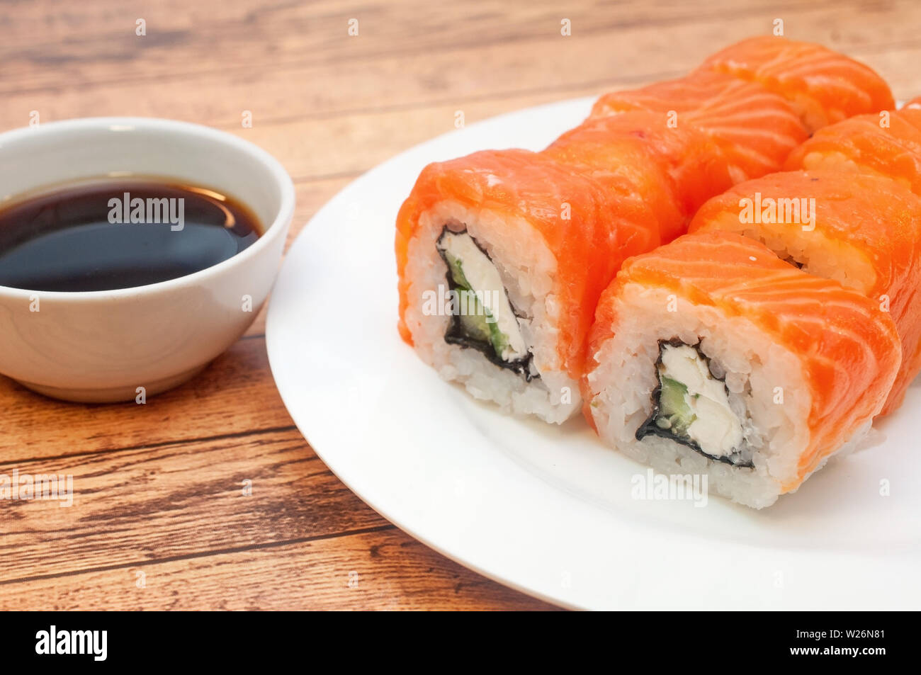 Brötchen mit Lachs Soja Sauce auf einer Platte Stockfoto