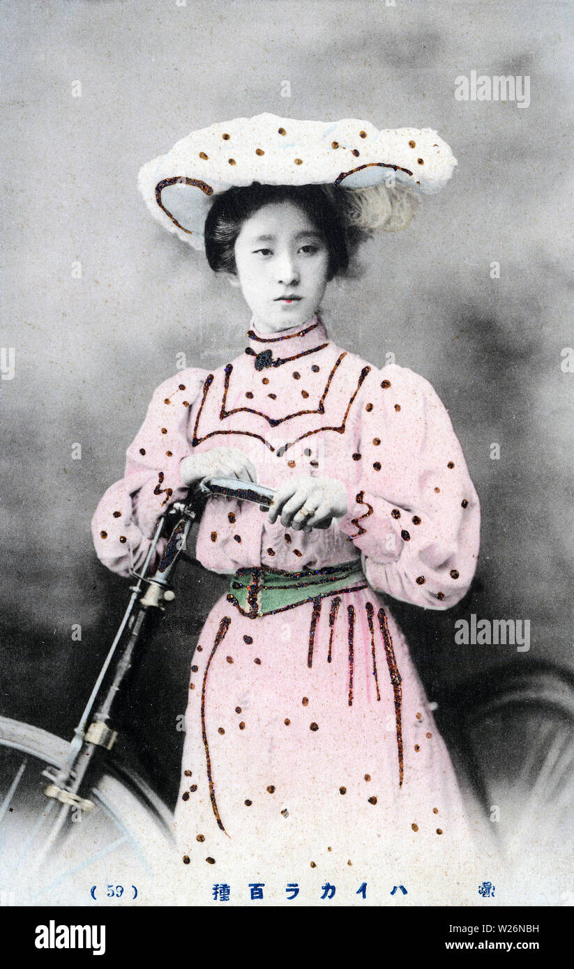 [1900s Japan - Japanische Frau in westlicher Kleidung mit Fahrrad] - eine Frau wirft mit einem Fahrrad, das Tragen eines westlichen stil kleid und hut. 20. jahrhundert alte Ansichtskarte. Stockfoto