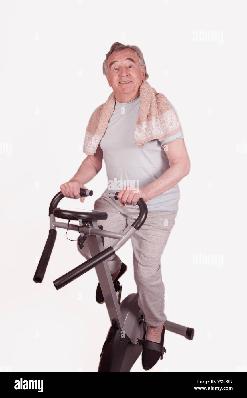 Senior mit Heimtrainer isoliert auf weißem Stockfoto