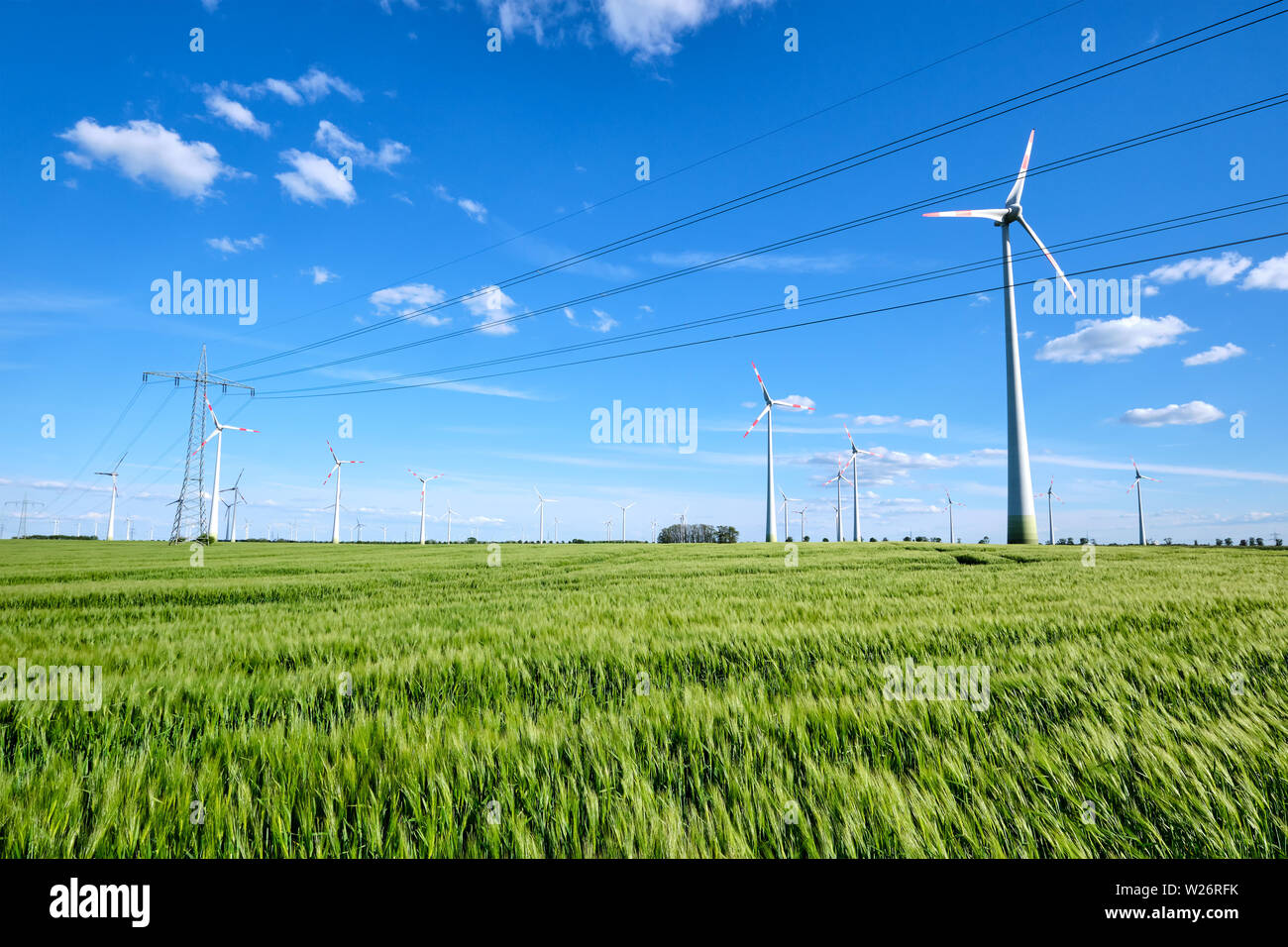 Stromleitungen und wind Motoren an einem sonnigen Tag in Deutschland gesehen Stockfoto