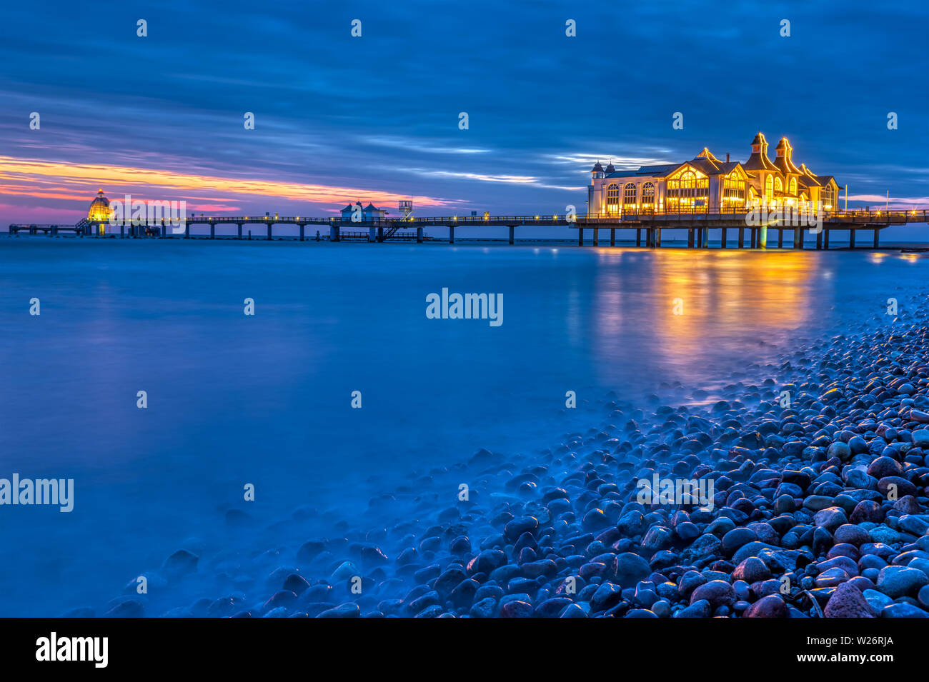 Das Meer Seebrücke von Sellin in der Nacht mit Kieseln im Vordergrund. Stockfoto